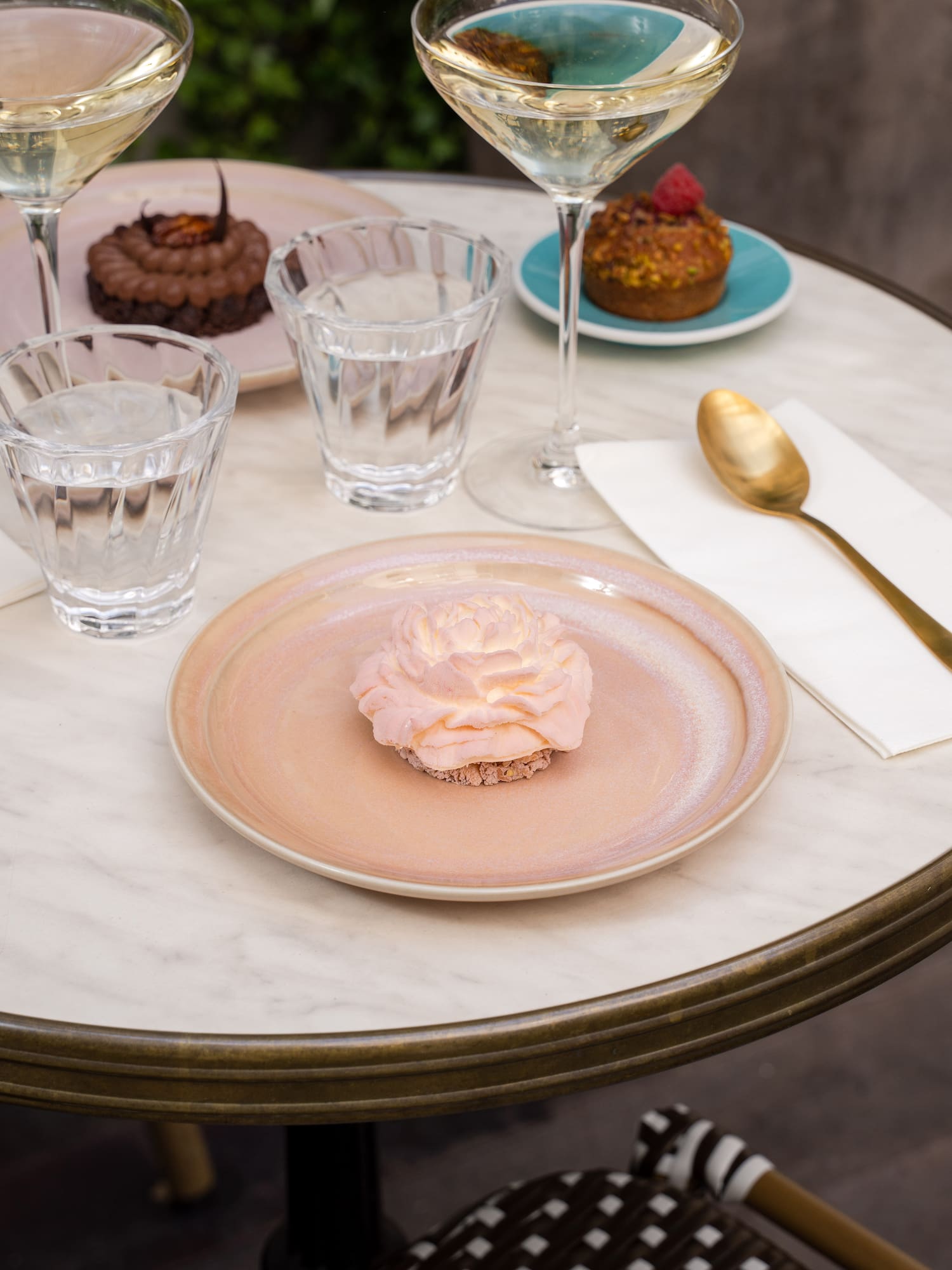 a plate with a pink frosting on it and glasses of water on a table