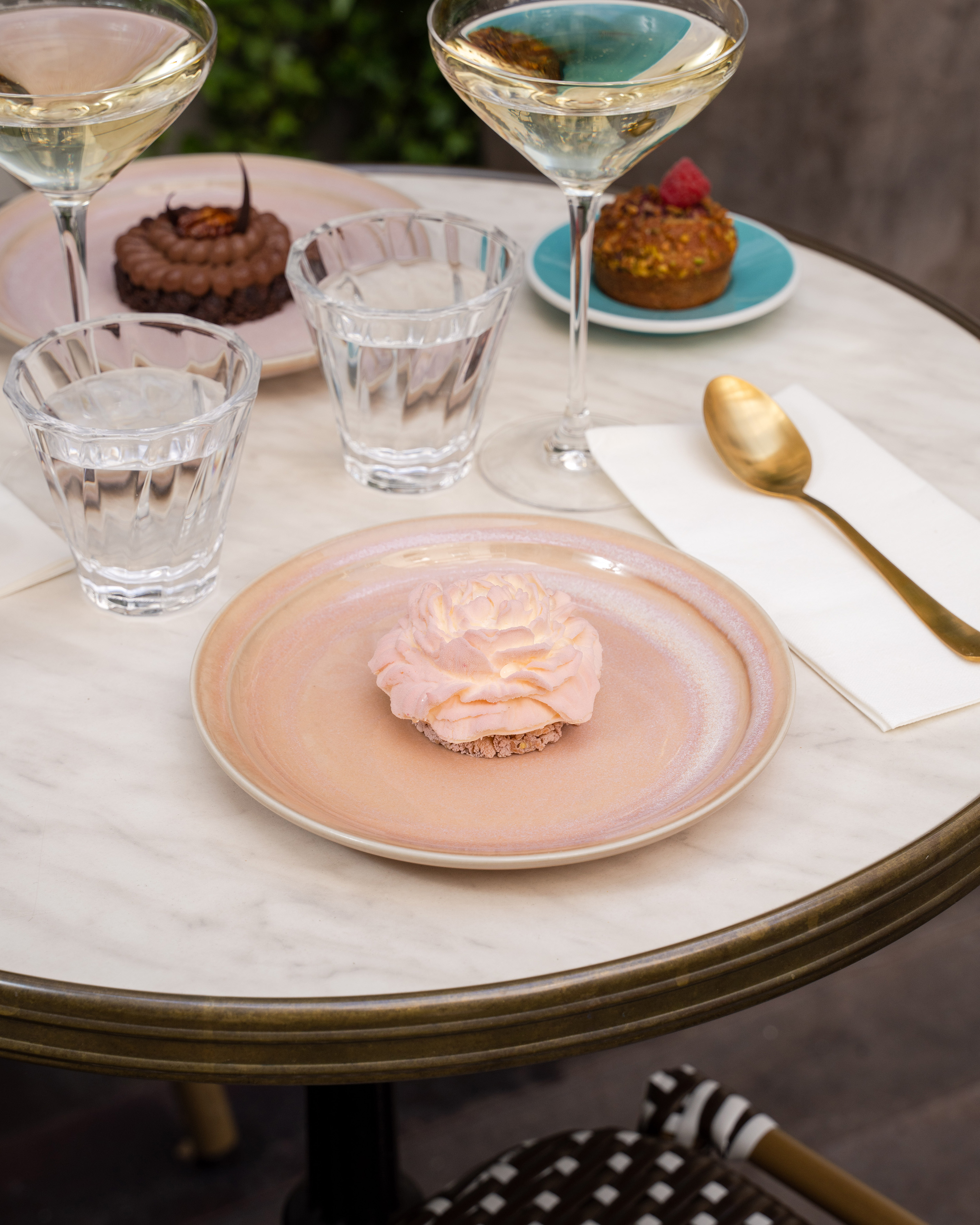 a plate with a pink frosting on it and glasses of water on a table