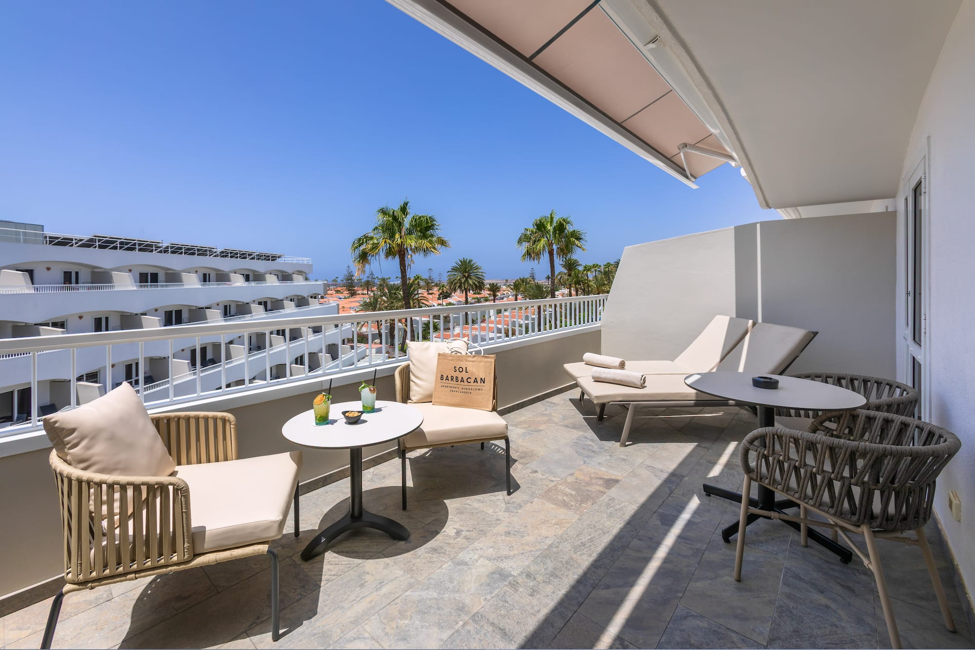 a patio with chairs and tables on a balcony