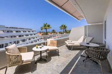 a patio with chairs and tables on a balcony