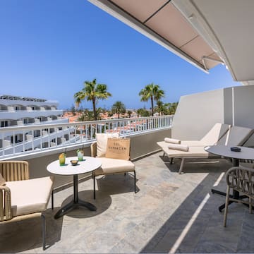 a patio with chairs and tables on a balcony