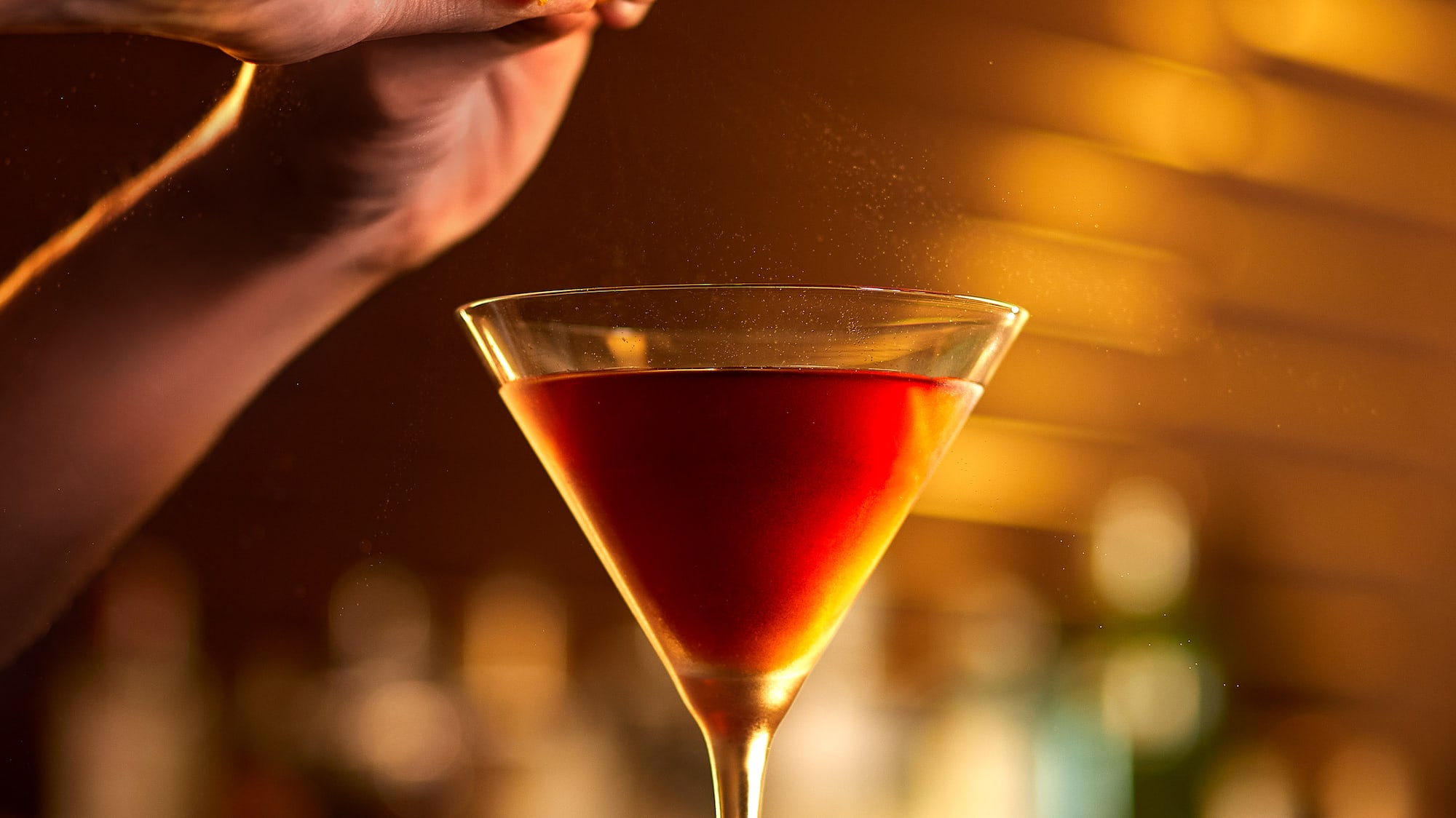 a person adding orange to a drink