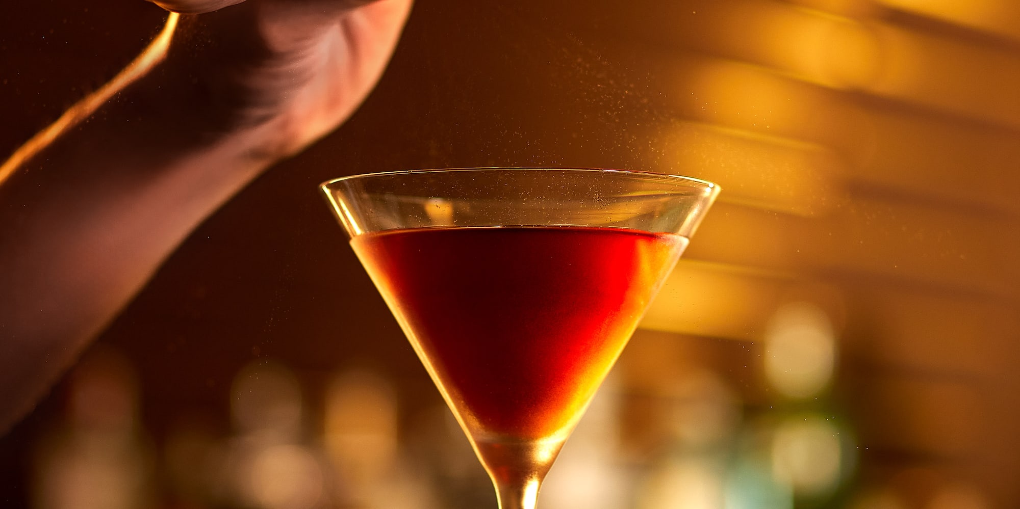 a person adding orange to a drink