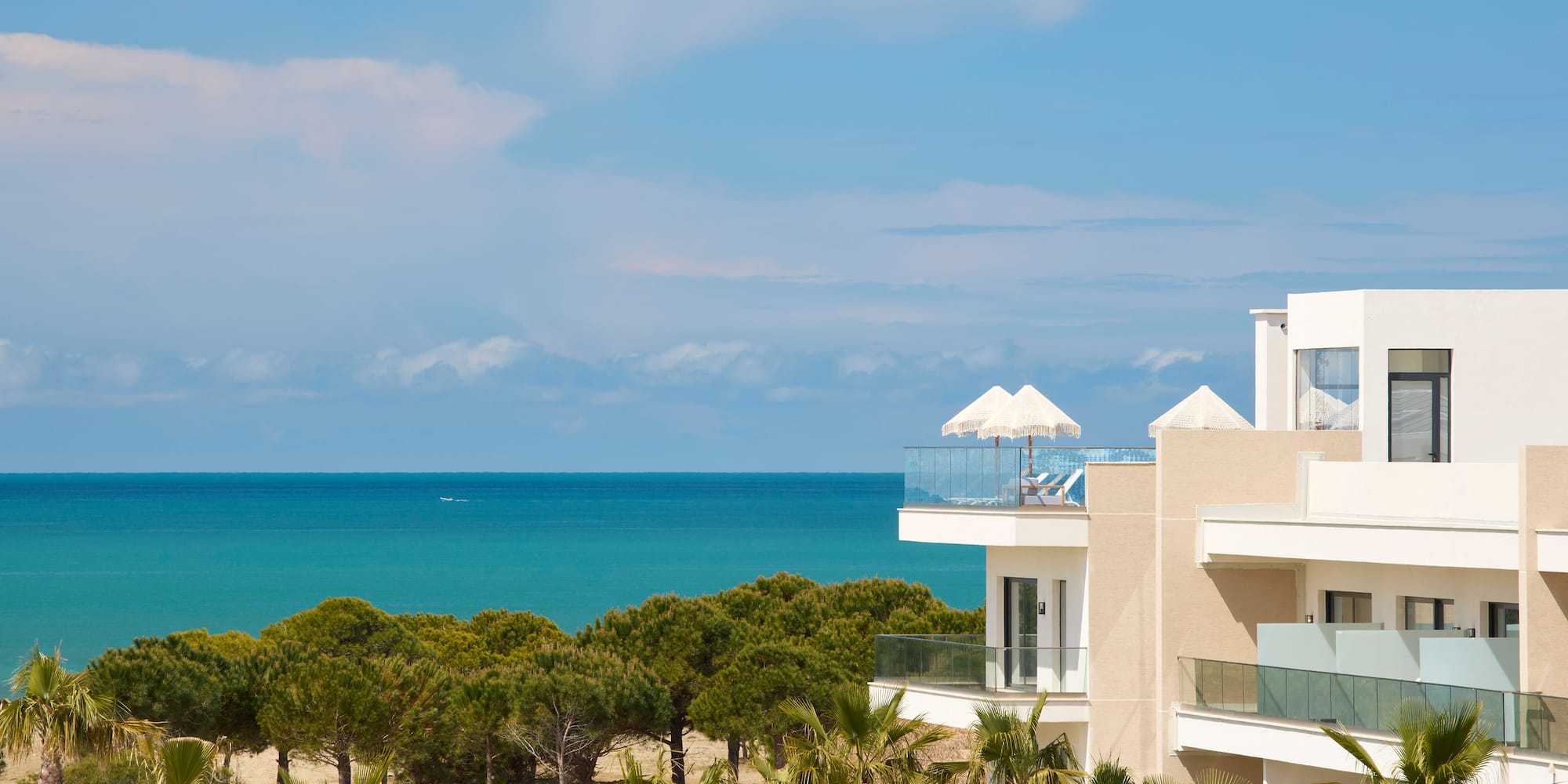 a building with trees and a beach in the background
