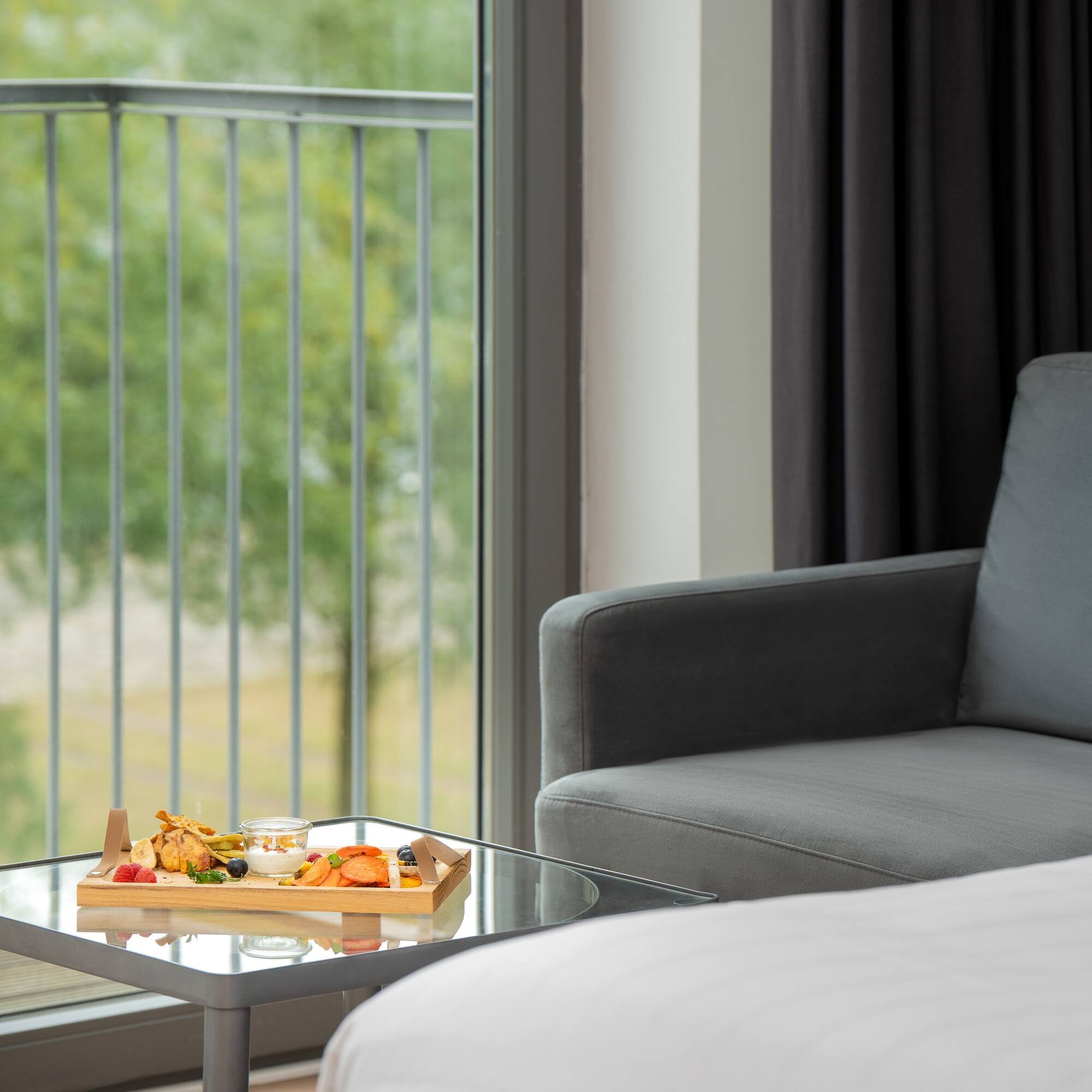 a tray of food on a table in a room with a couch and a balcony