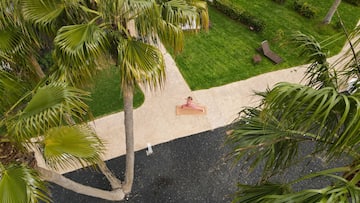 a person doing yoga on a mat in a yard