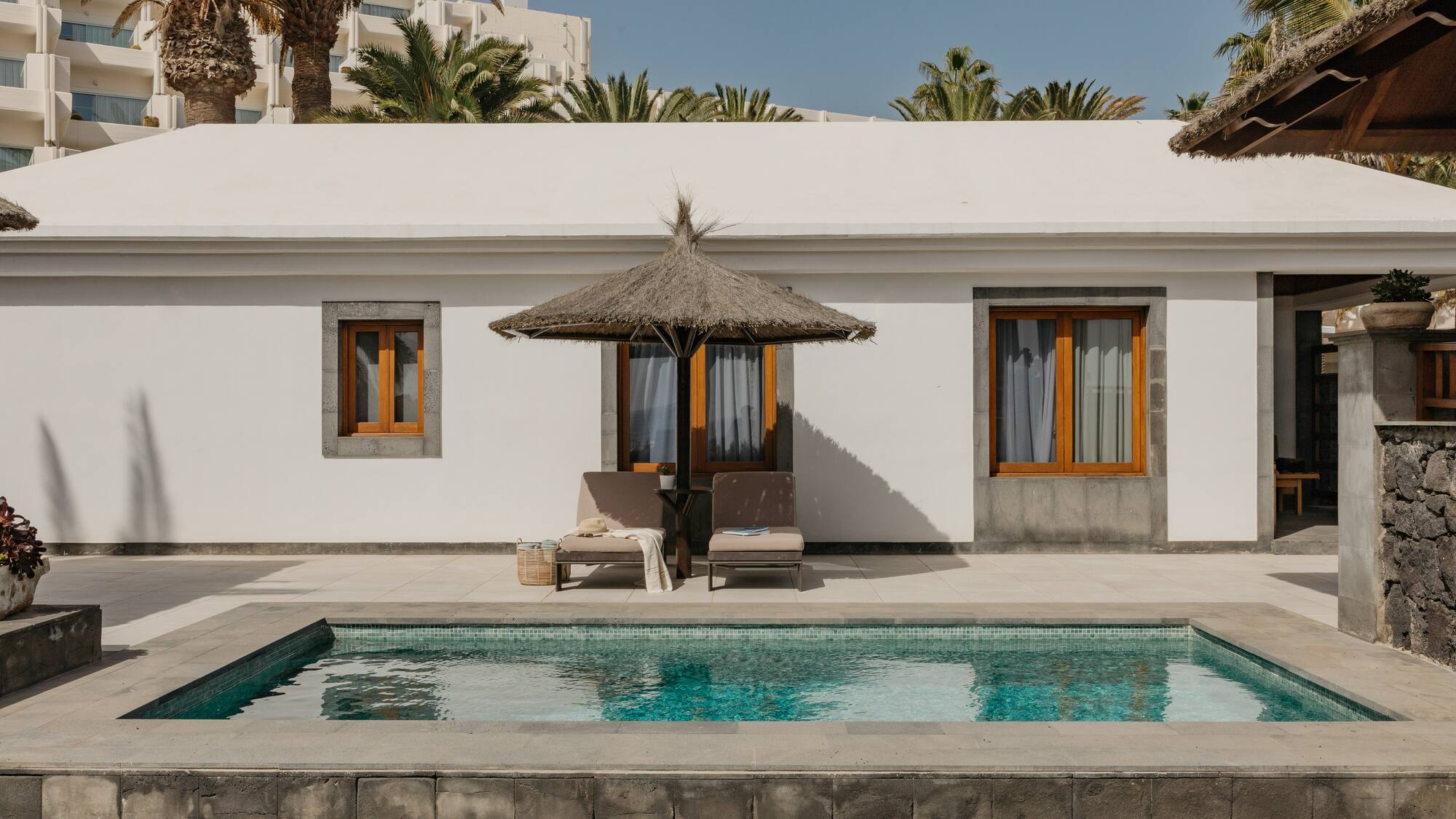 a pool in front of a white building
