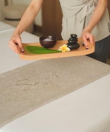 a person holding a tray with a bowl and a bowl on it