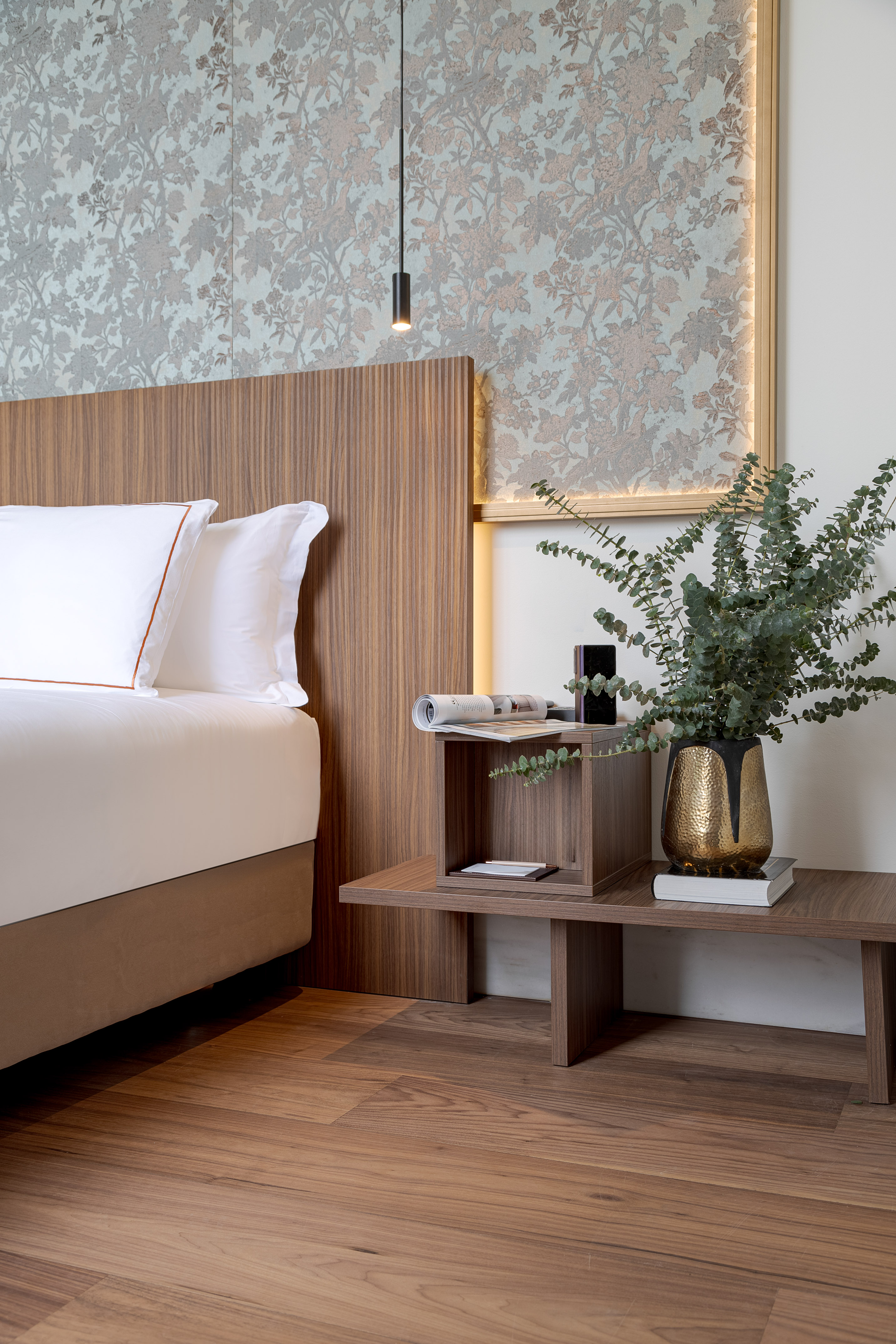 a bed with a plant on a table