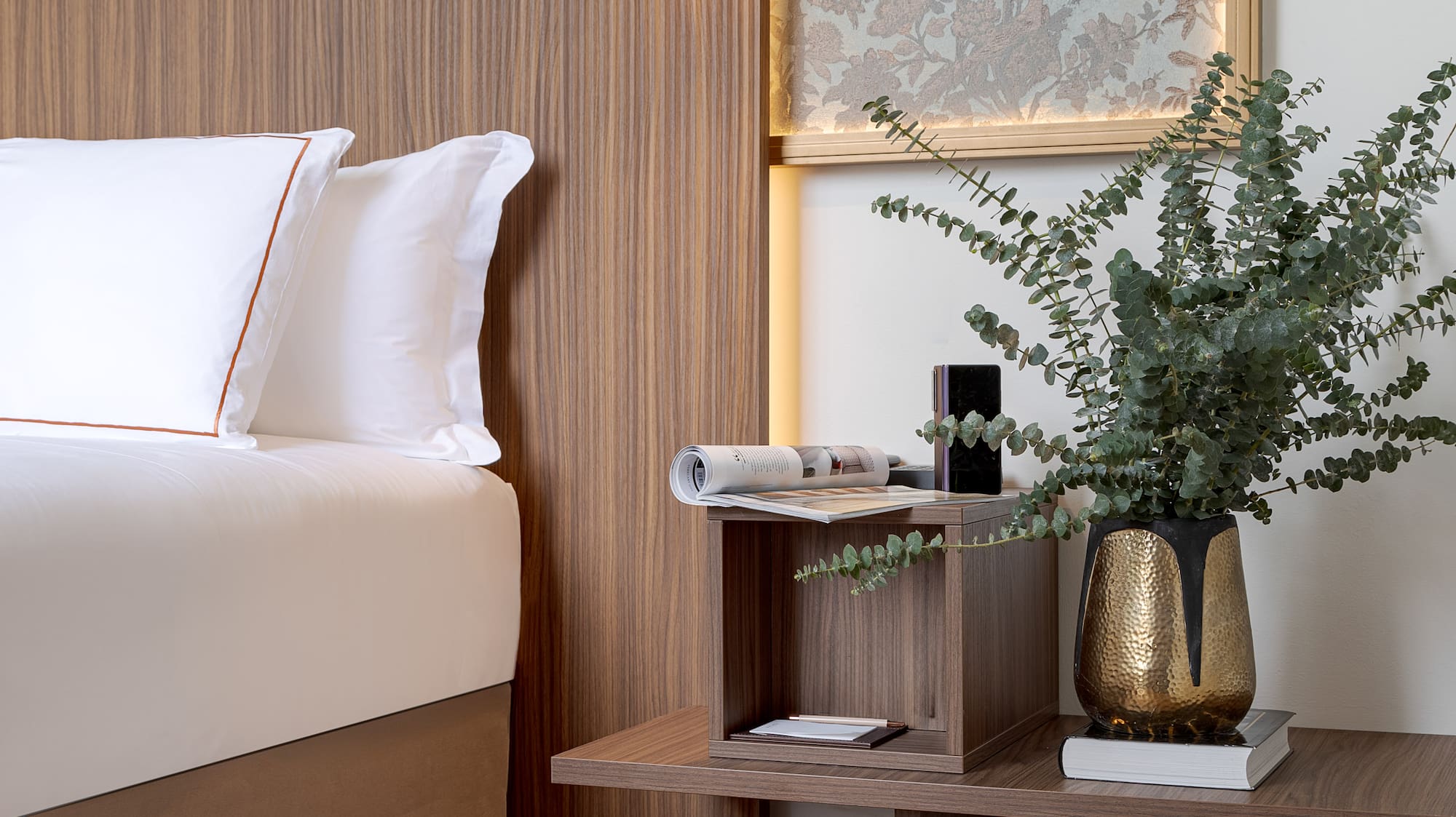 a bed with a plant on a table