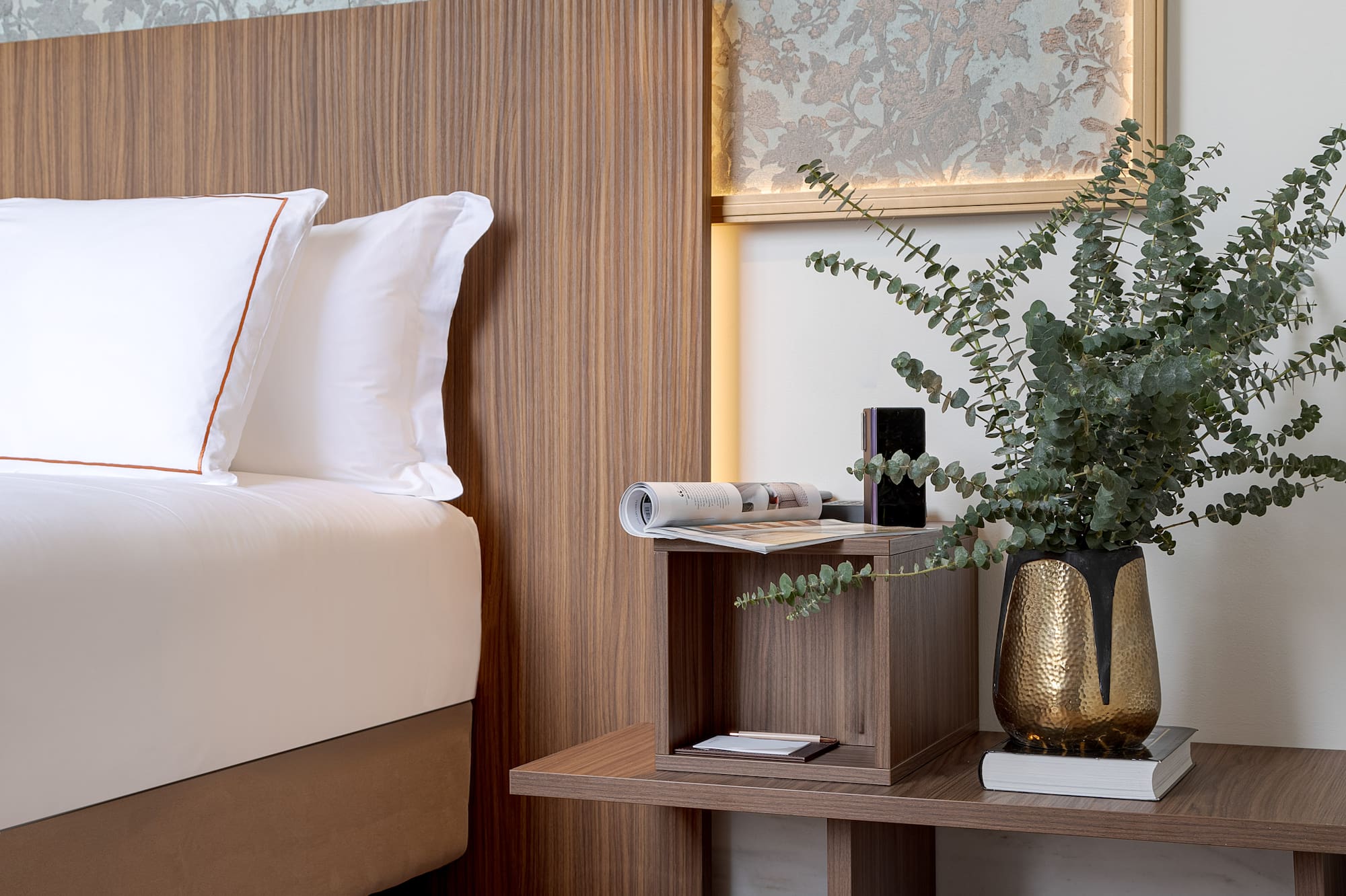 a bed with a plant on a table