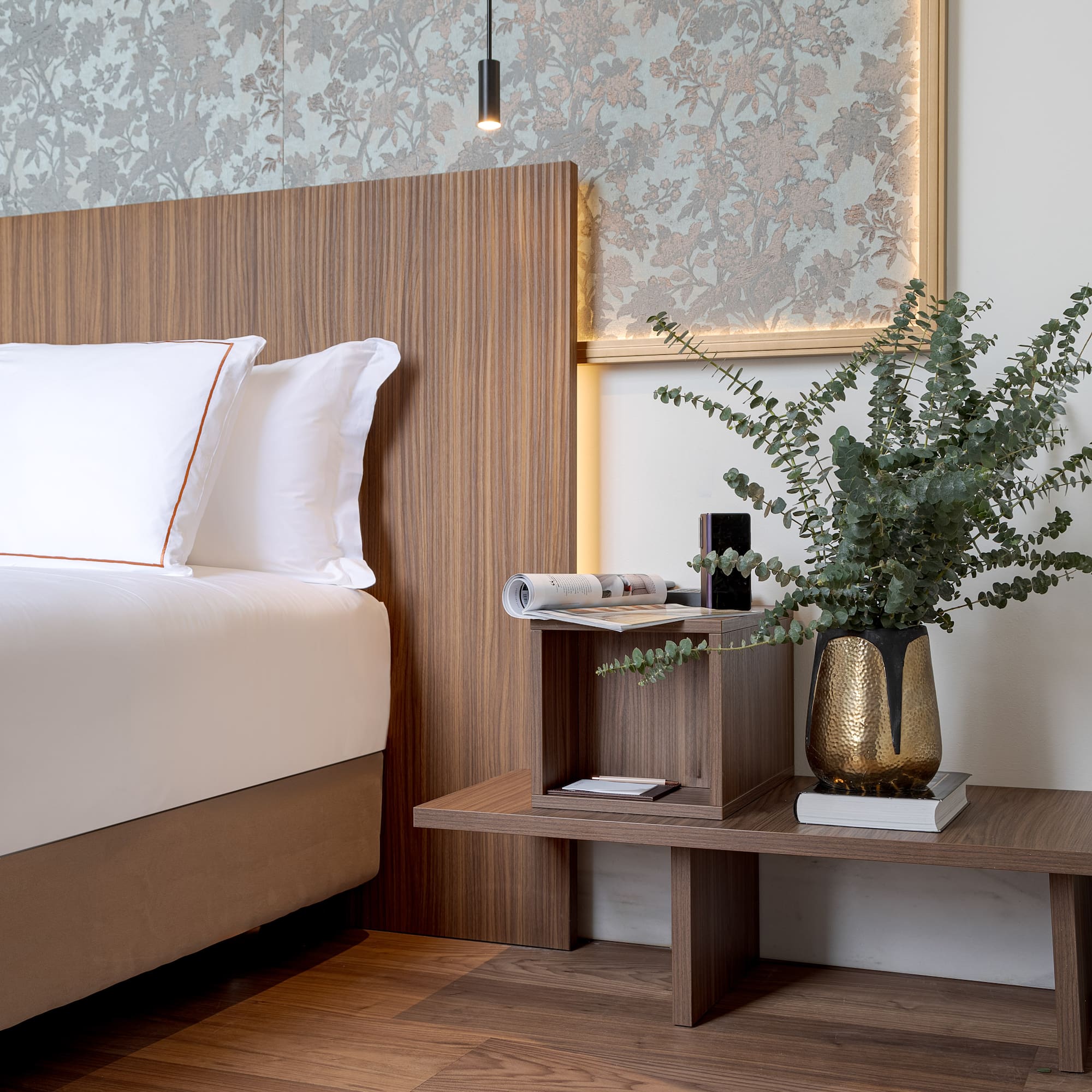 a bed with a plant on a table