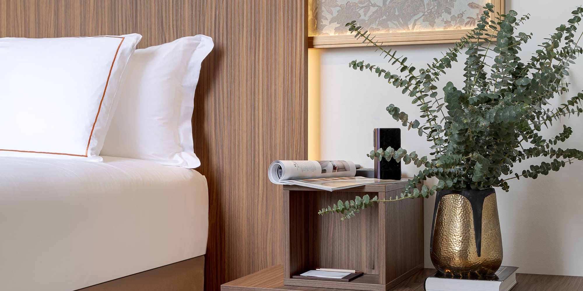 a bed with a plant on a table