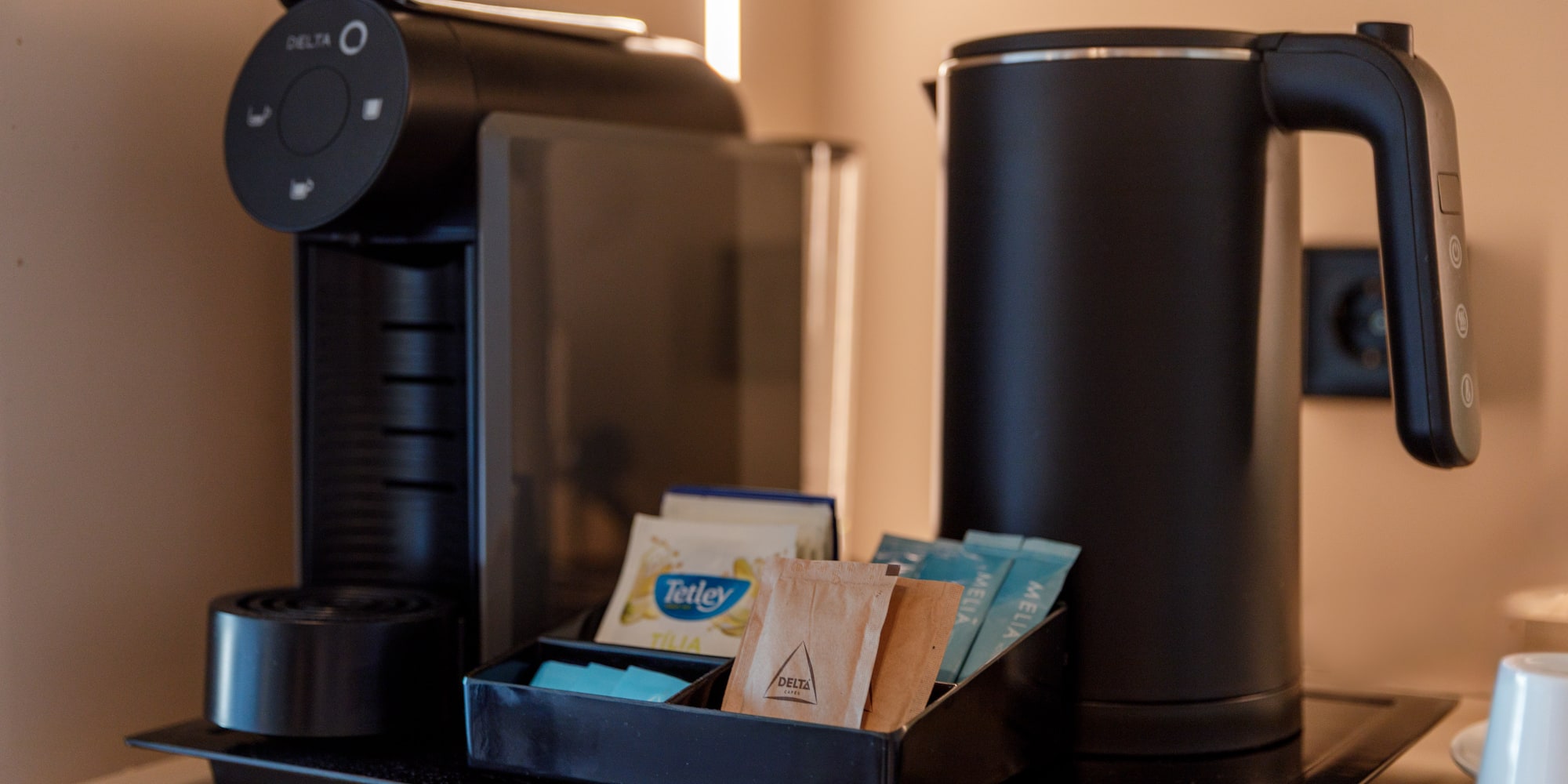 a coffee machine with a tray of tea packets