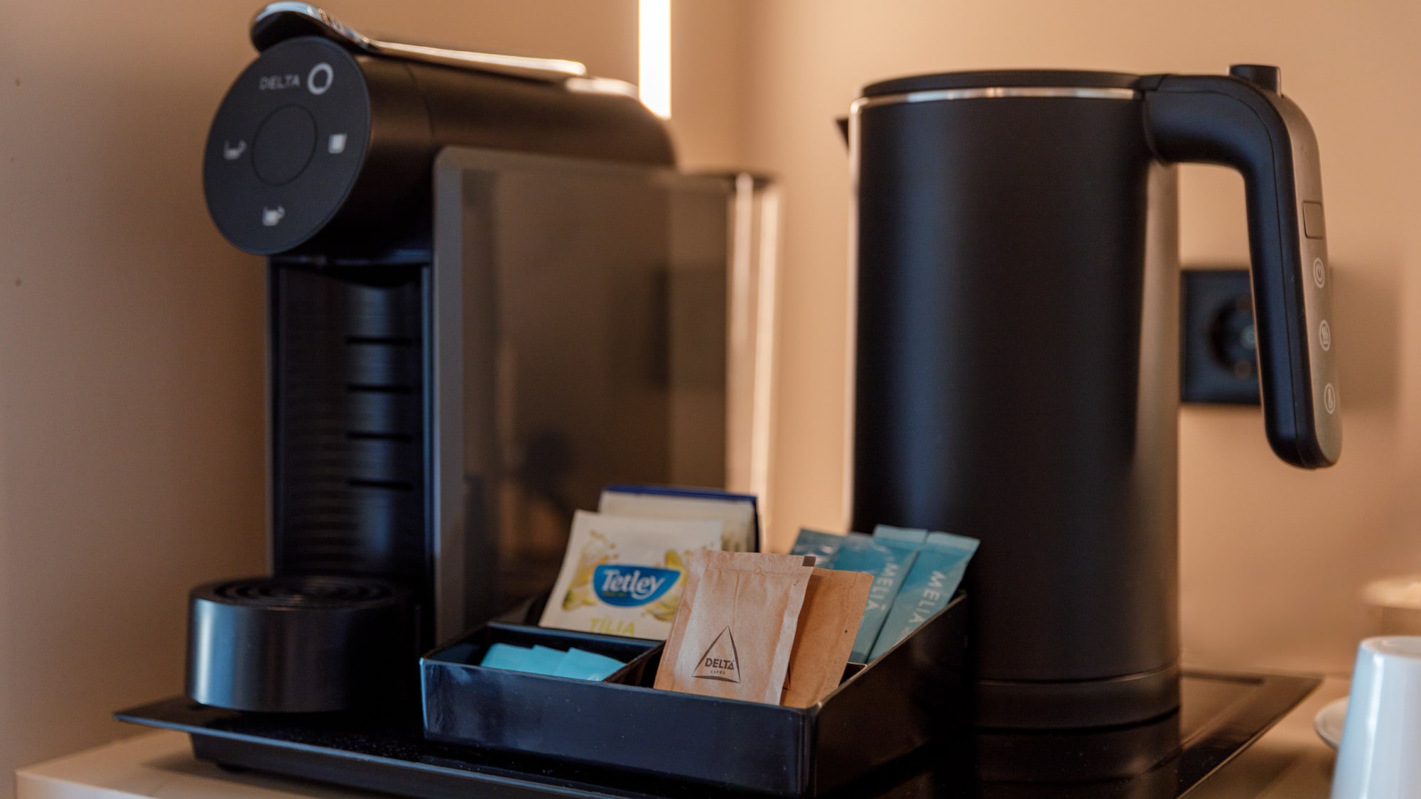 a coffee machine with a tray of tea packets