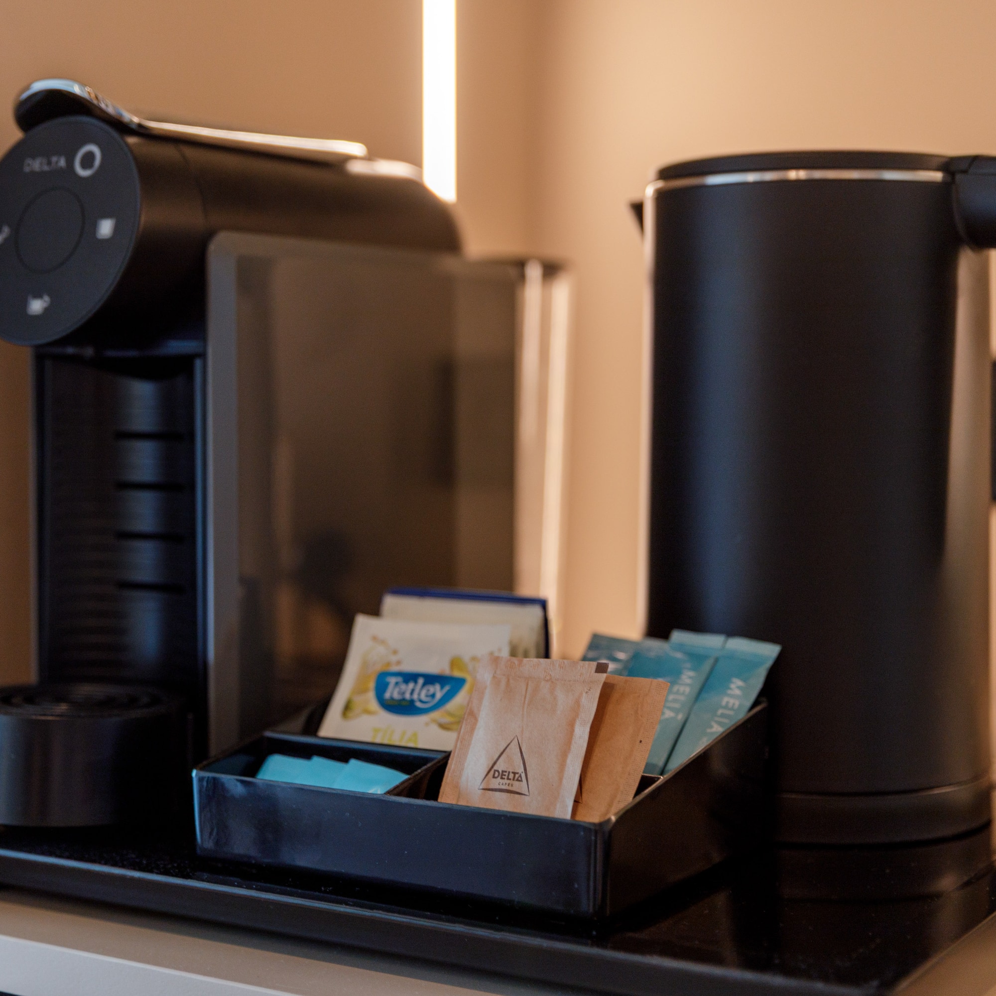 a coffee machine with a tray of tea packets