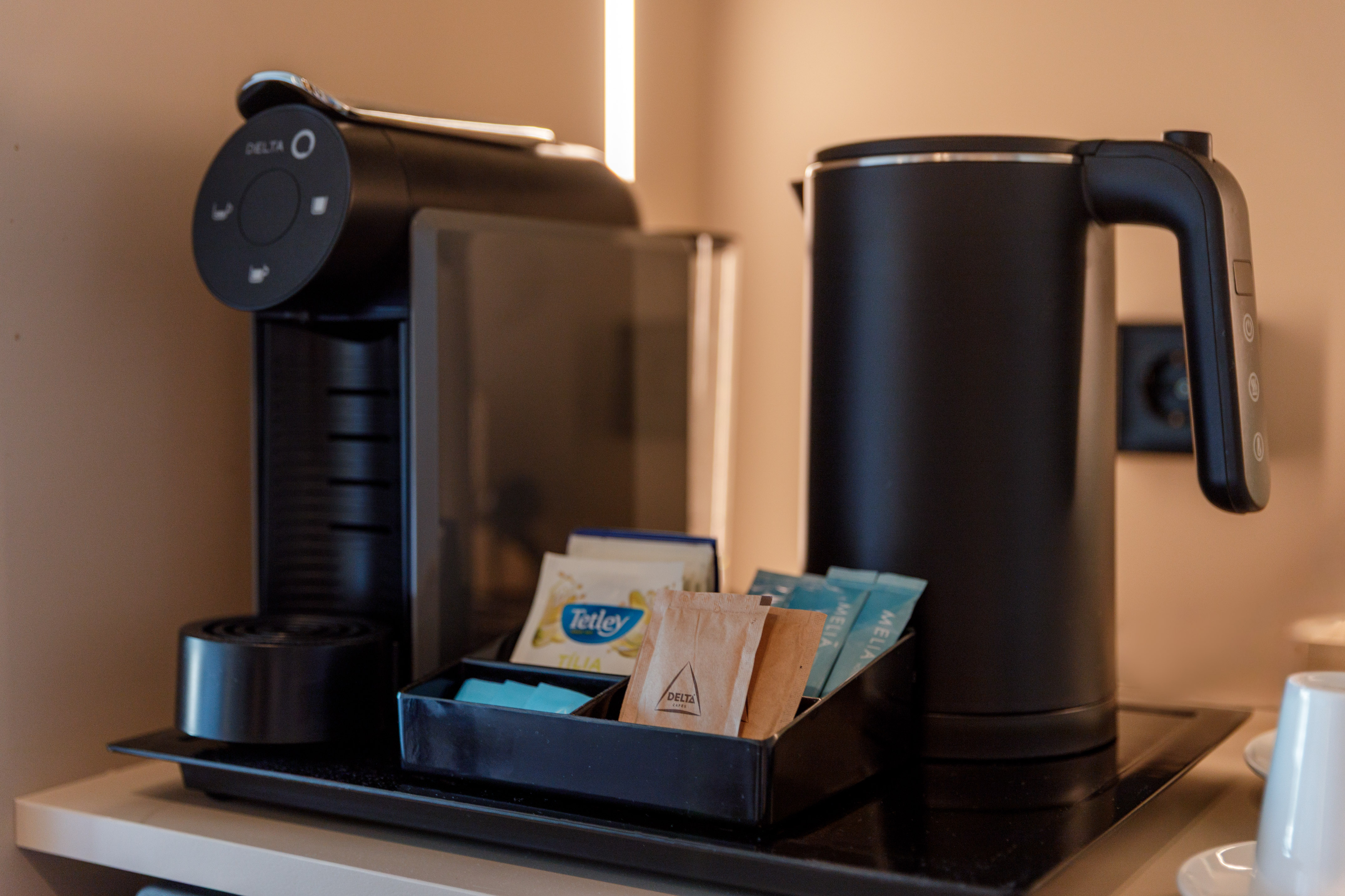 Hotel in-room coffee and tea station with Delta machine and kettle.