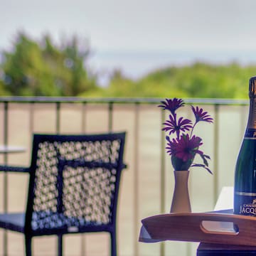 a bottle of champagne on a table with a vase of flowers