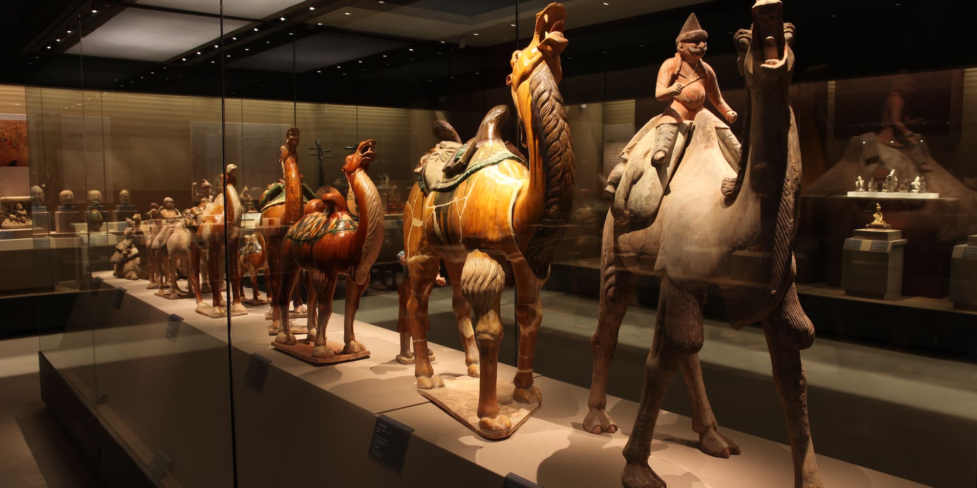 a group of statues of camels and a woman riding a camel