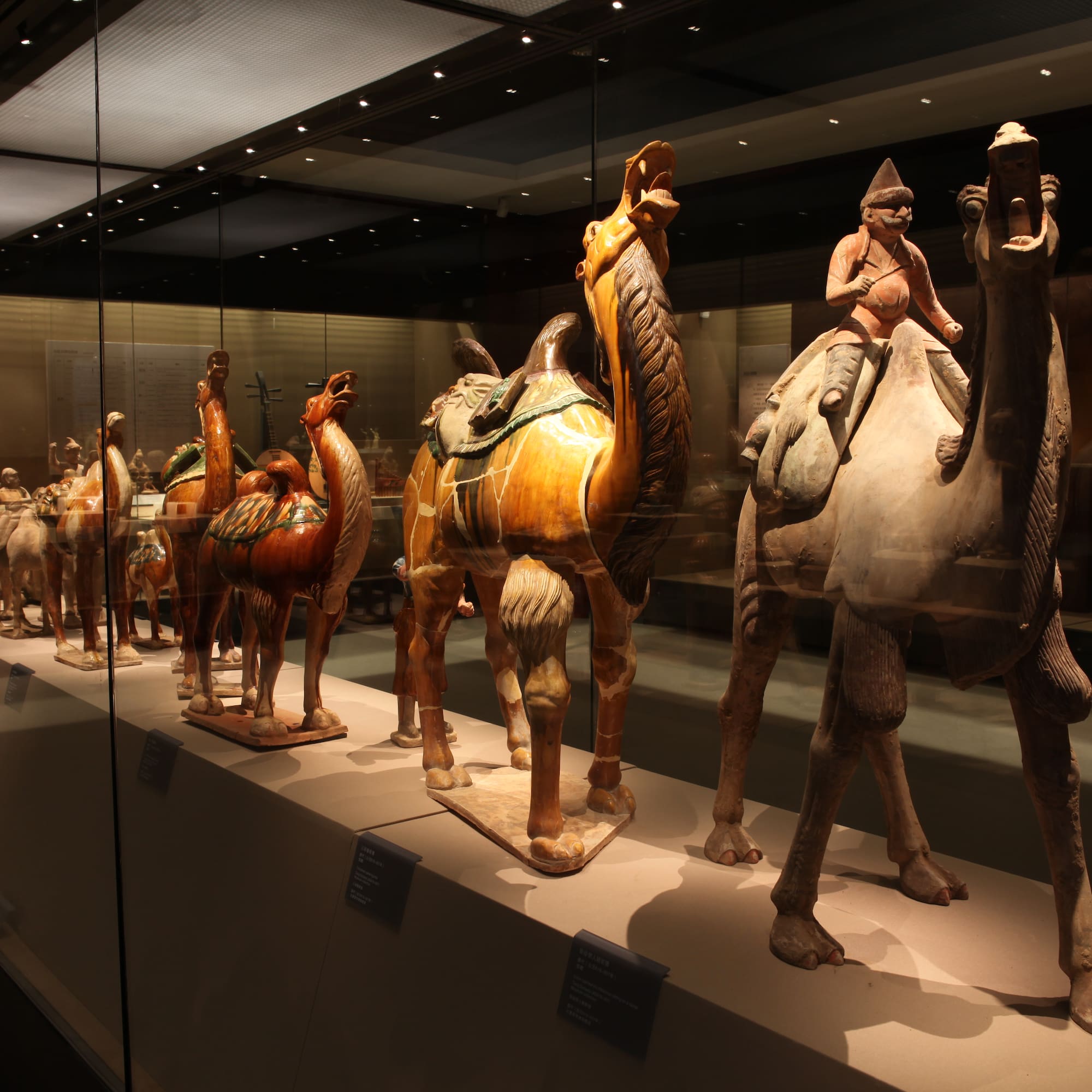 a group of statues of camels and a woman riding a camel