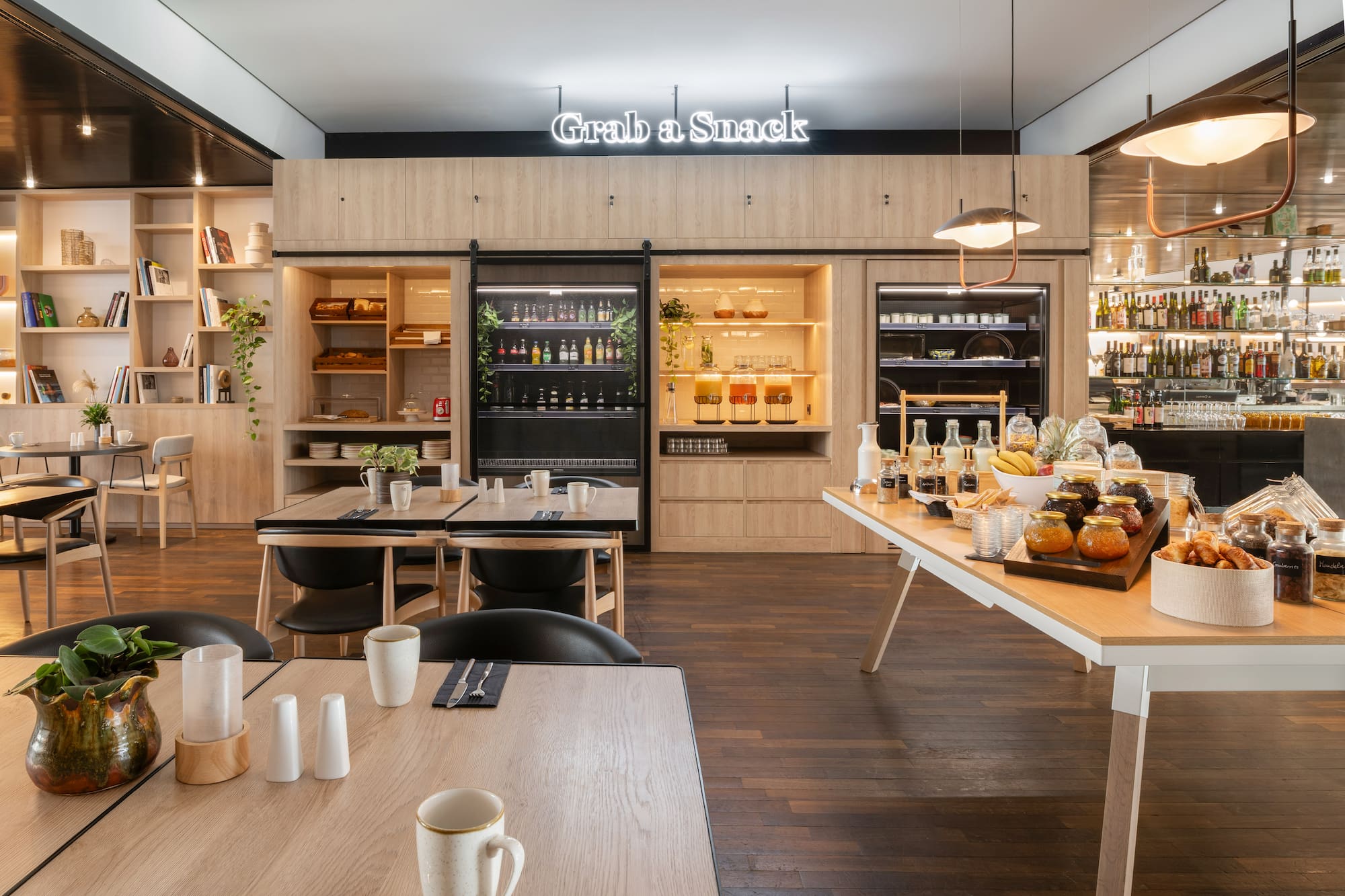 Hotel self-service snack bar with modern buffet, "Grab a Snack" sign, dining.