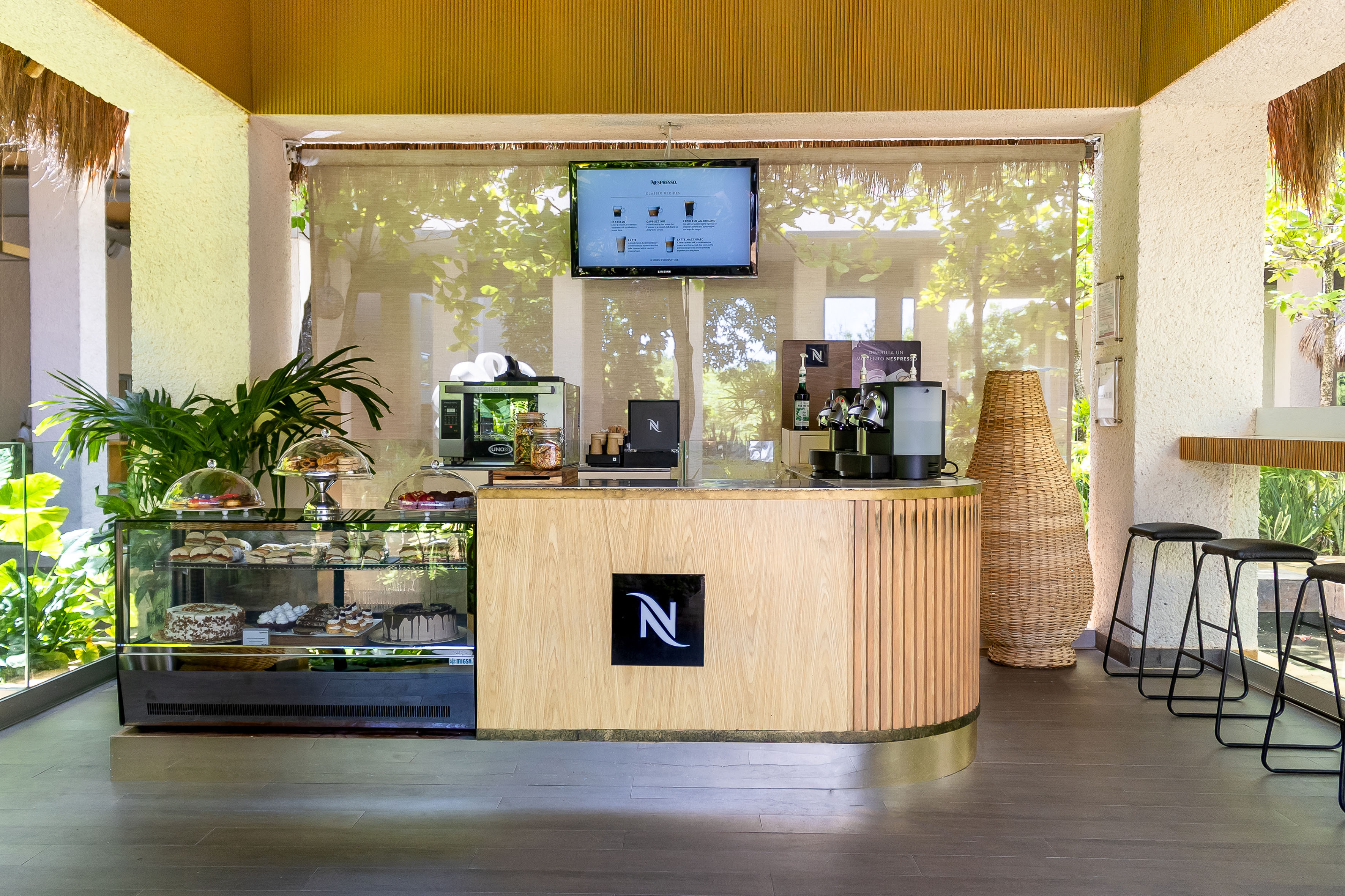 Nespresso coffee station with pastry case and menu.