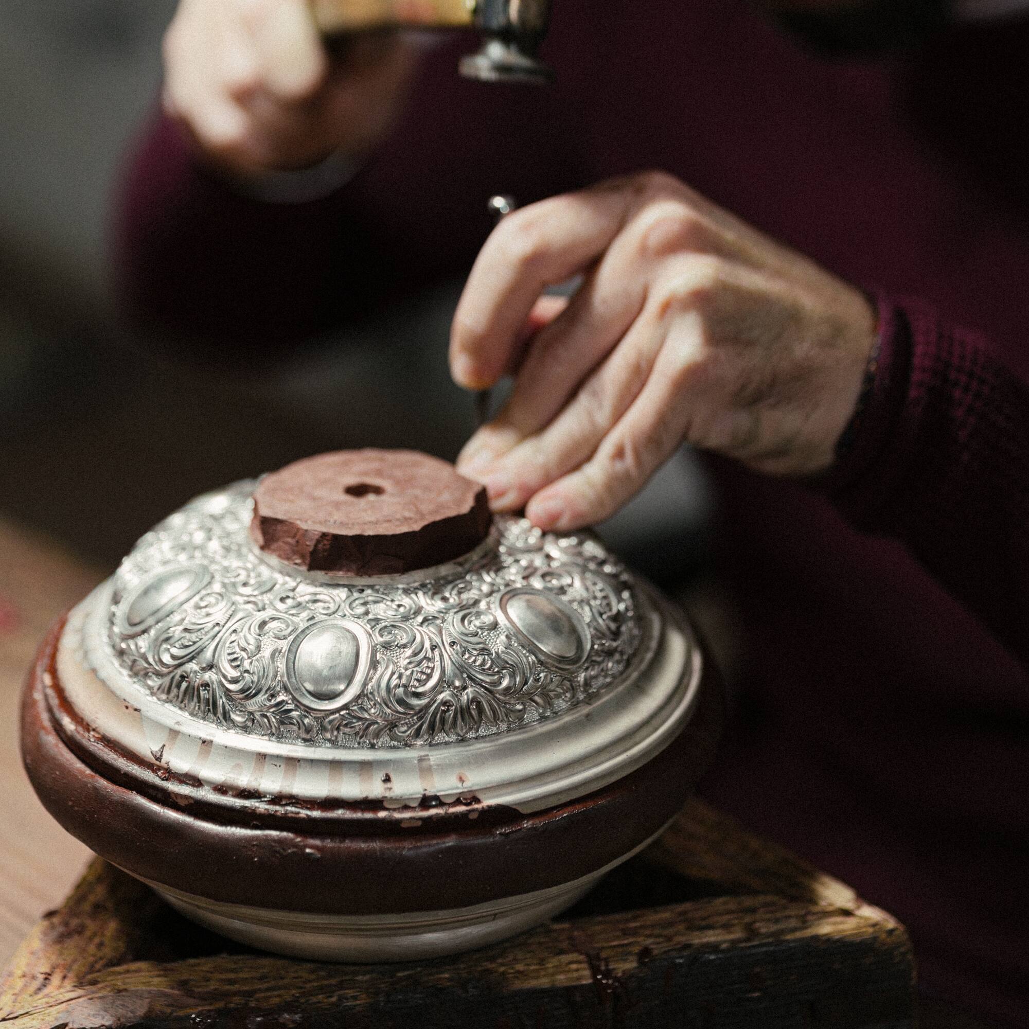 a person using a hammer to polish a bowl
