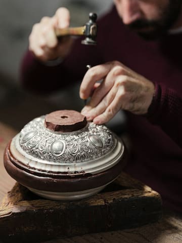 a person using a hammer to polish a bowl