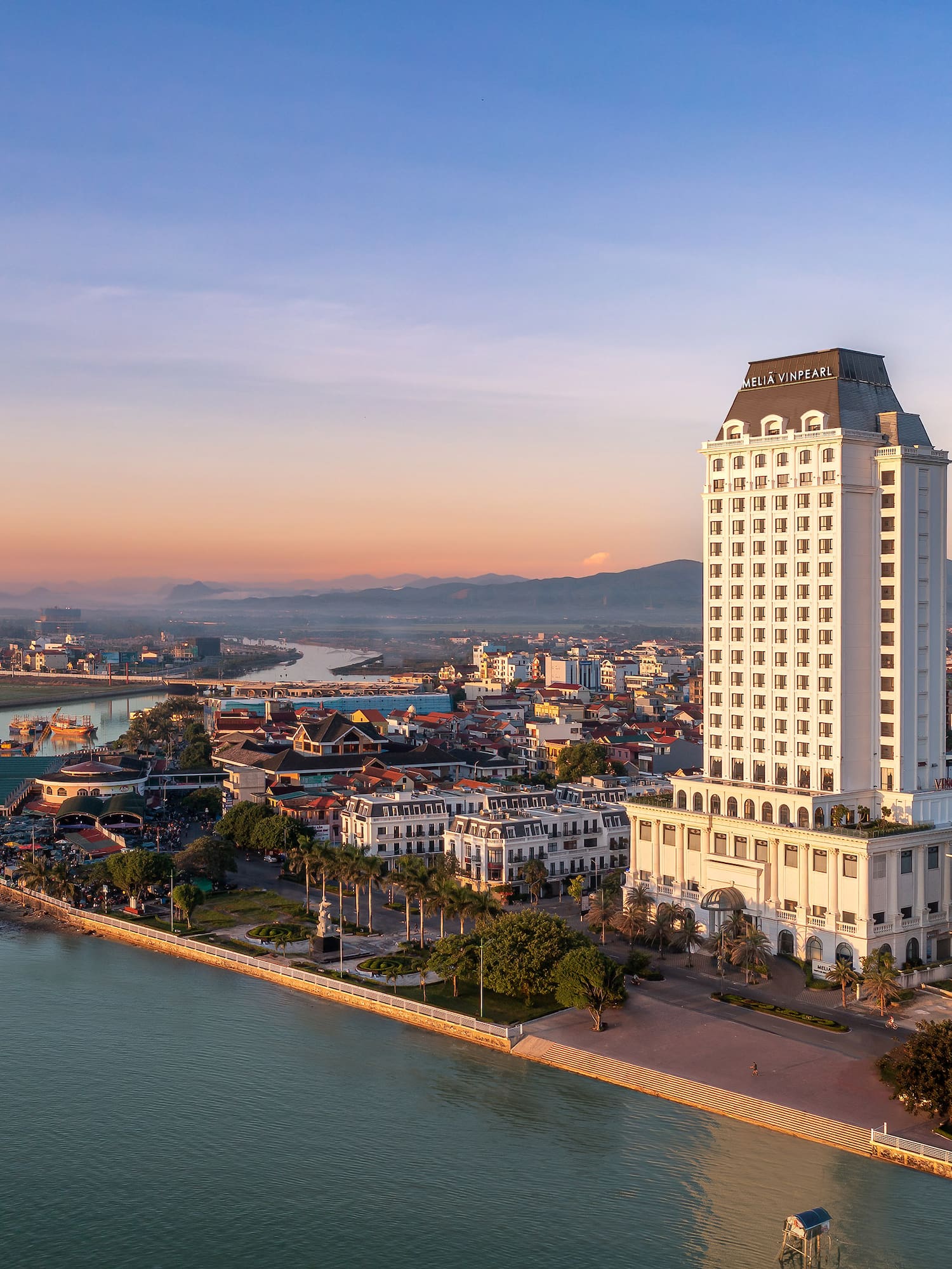 a large white building next to a body of water
