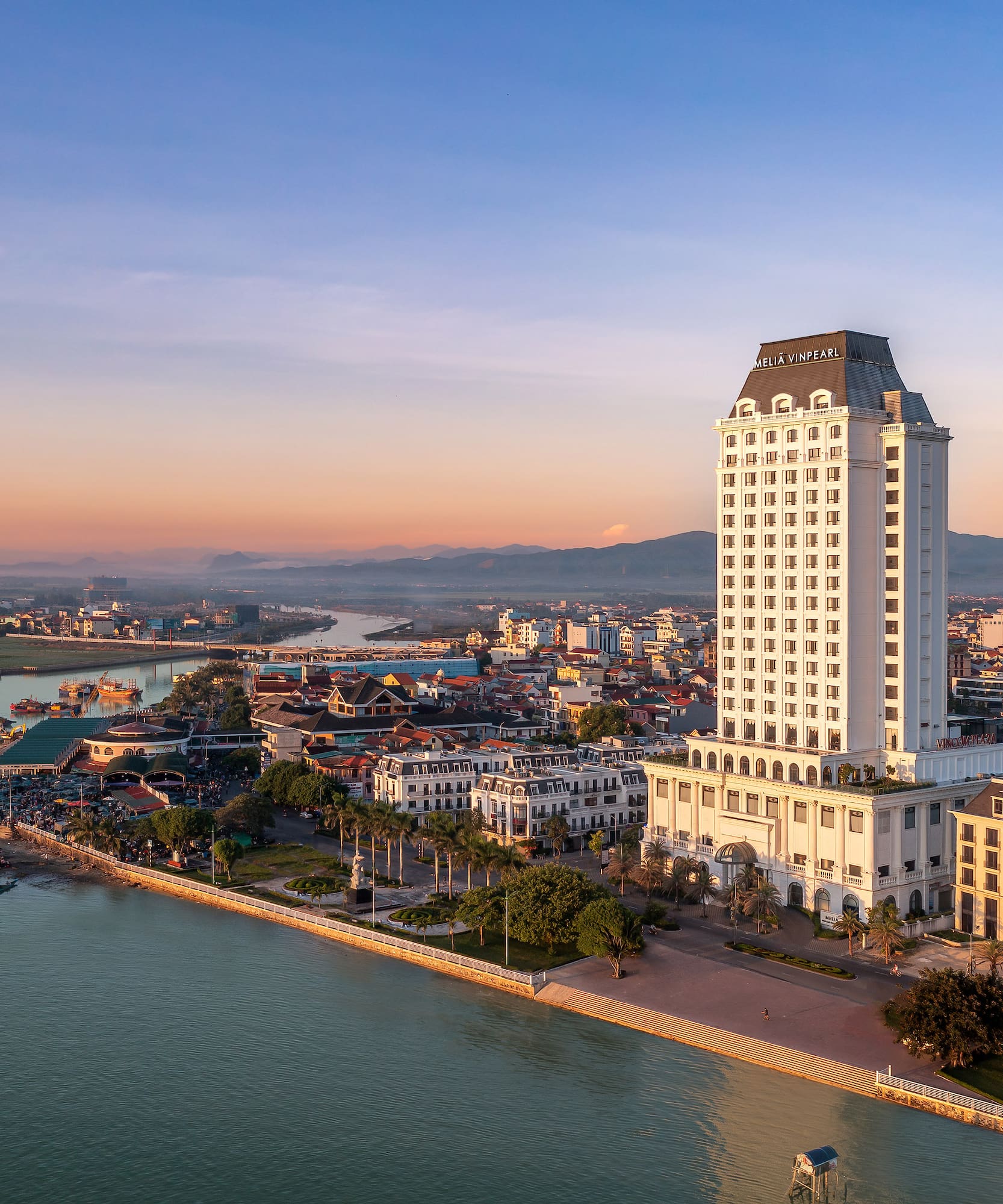 a large white building next to a body of water