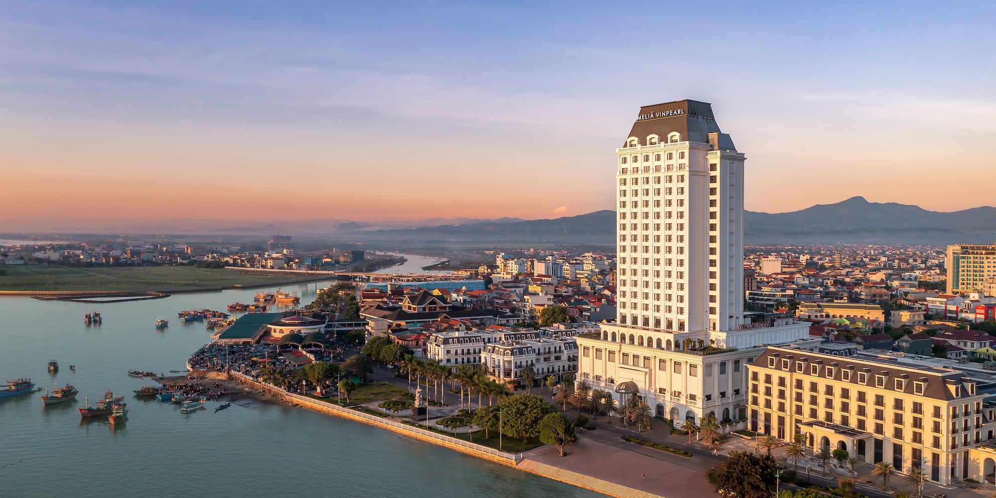 a large white building next to a body of water