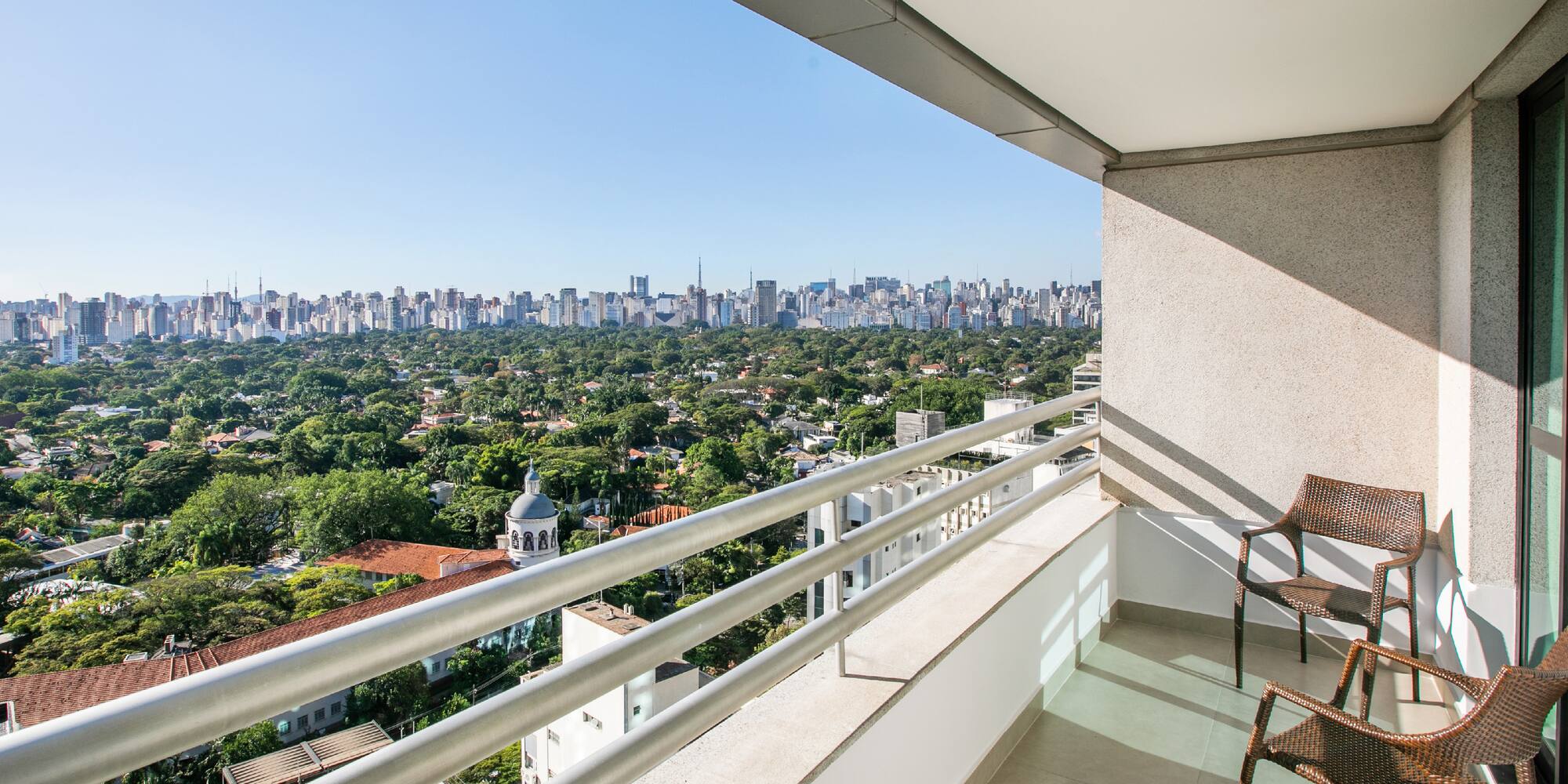 a balcony with a chair and a city view