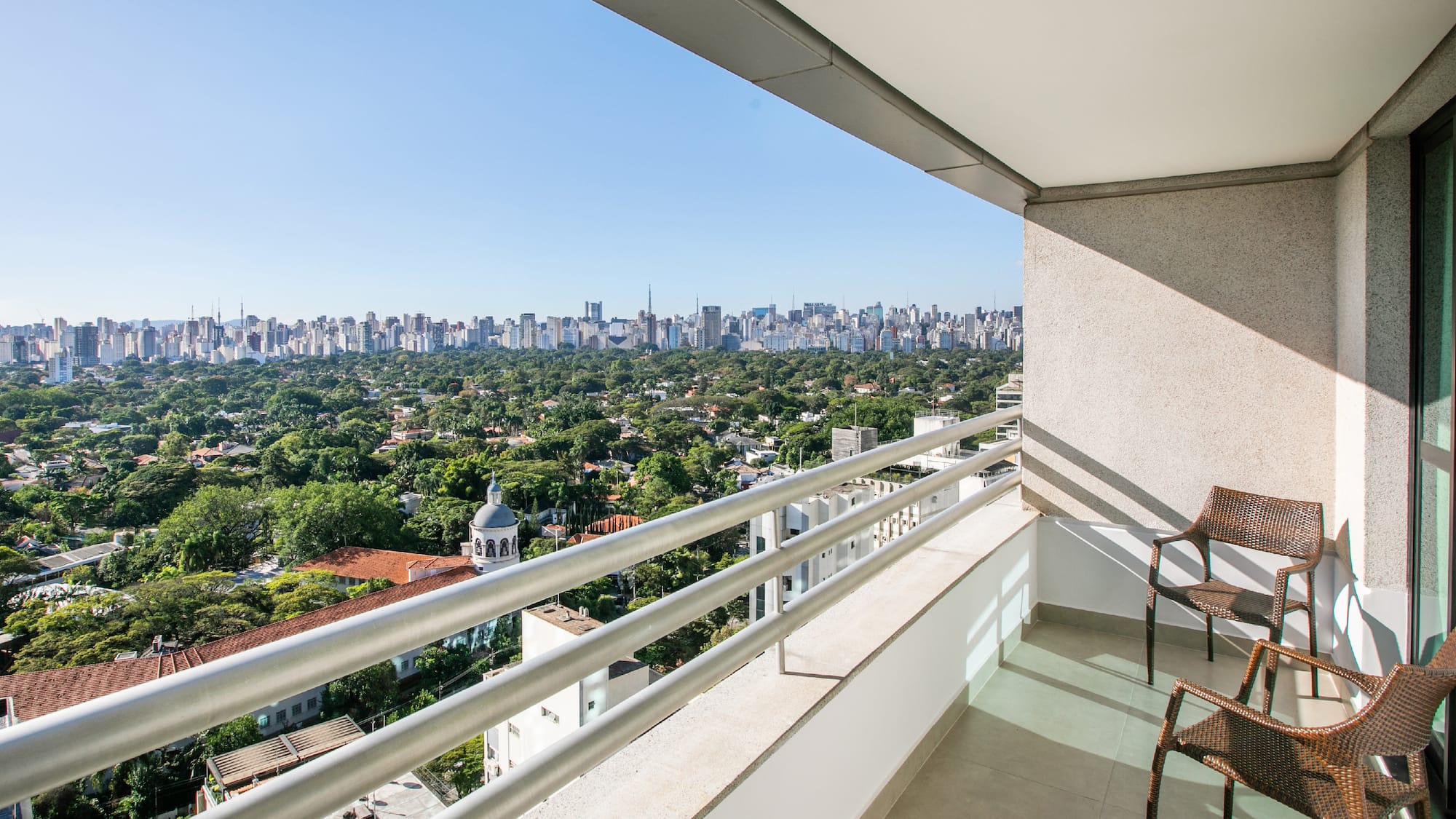 a balcony with a chair and a city view