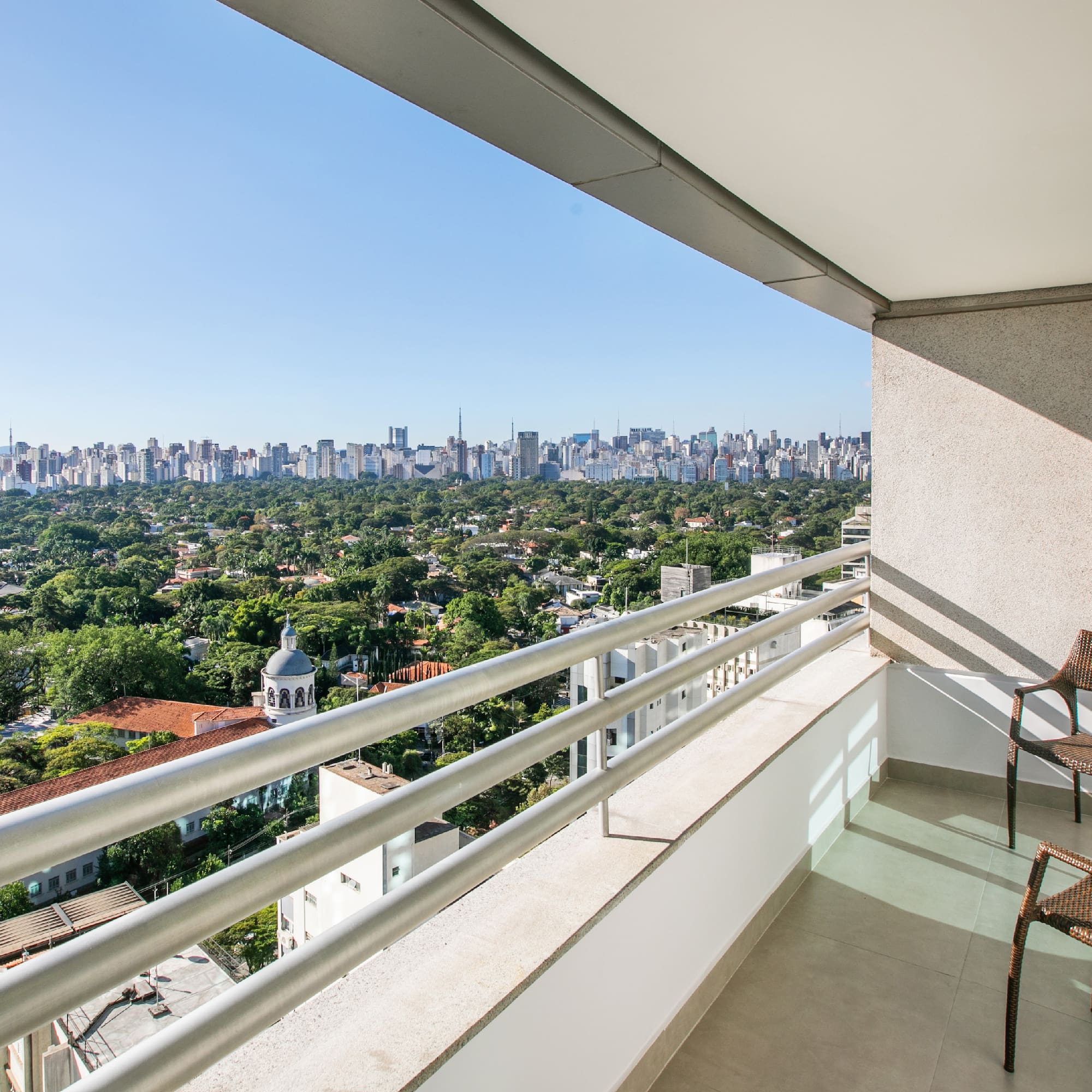 a balcony with a chair and a city view