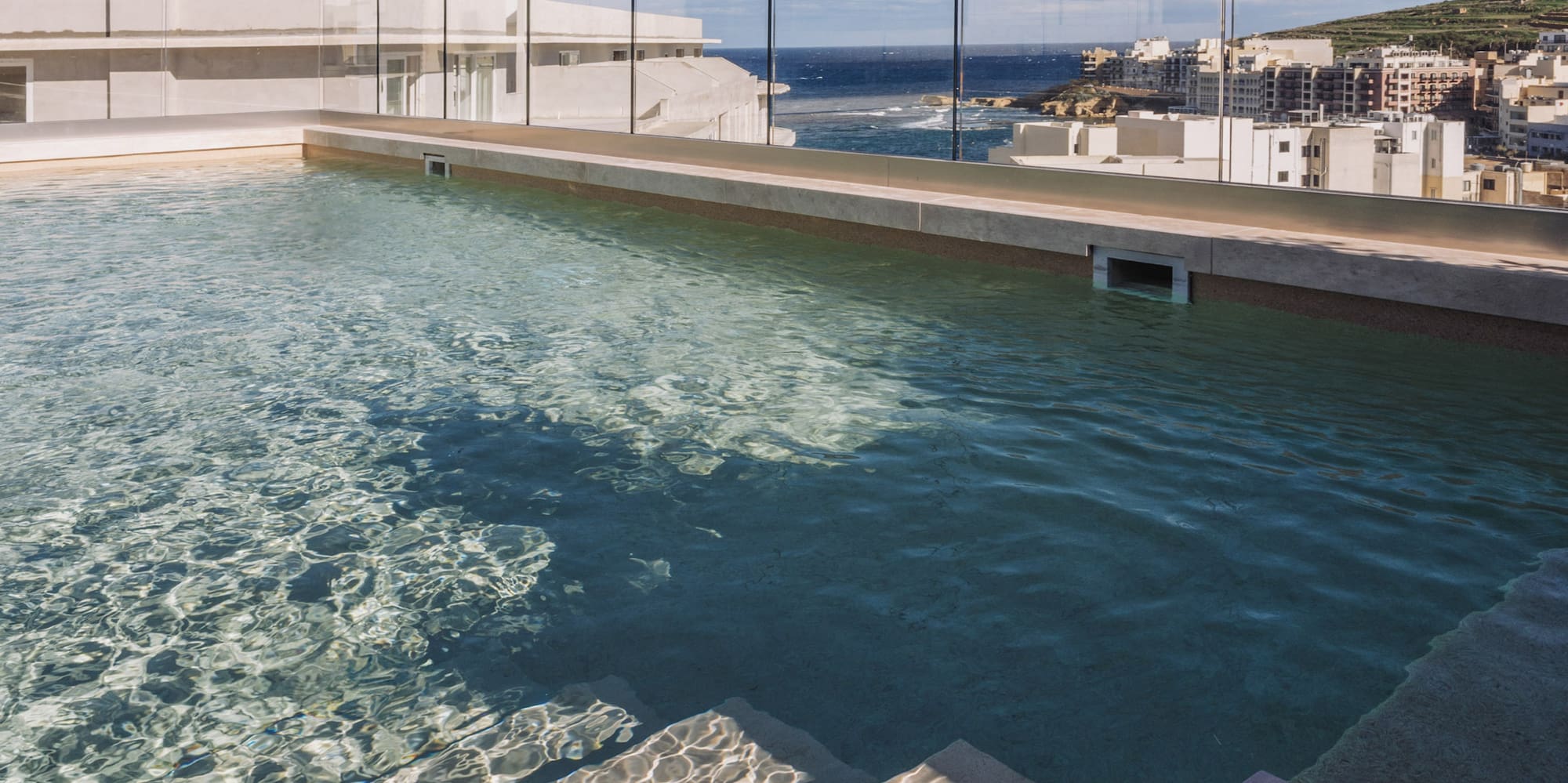 a pool with steps leading to a building