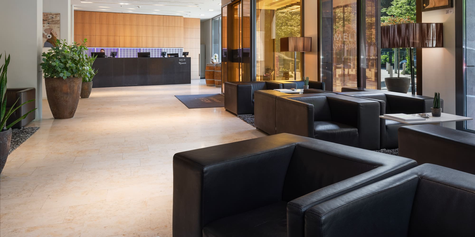 a lobby with black leather couches and a reception desk