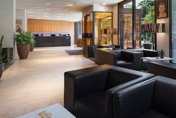 a lobby with black leather couches and a reception desk