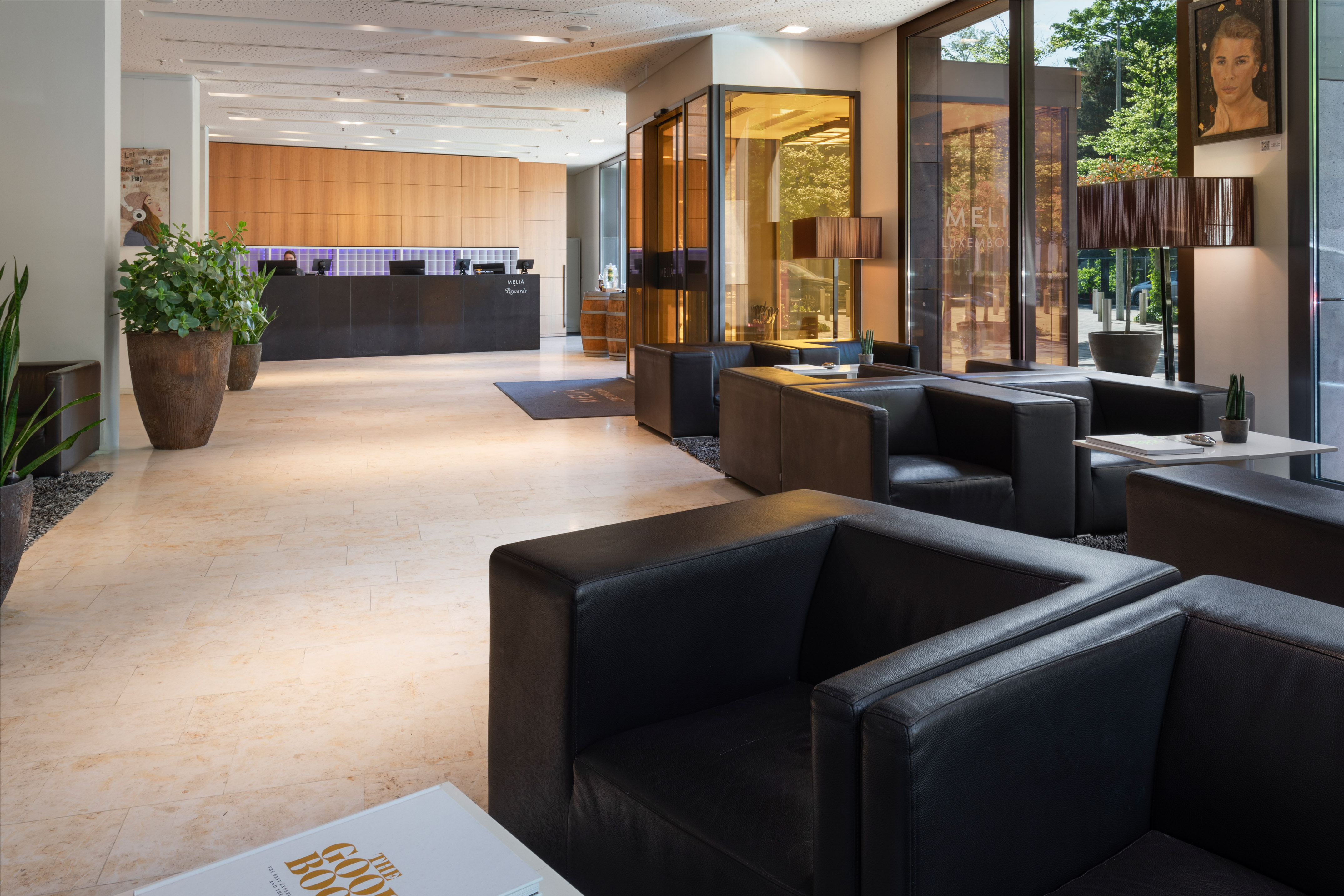a lobby with black leather couches and a reception desk