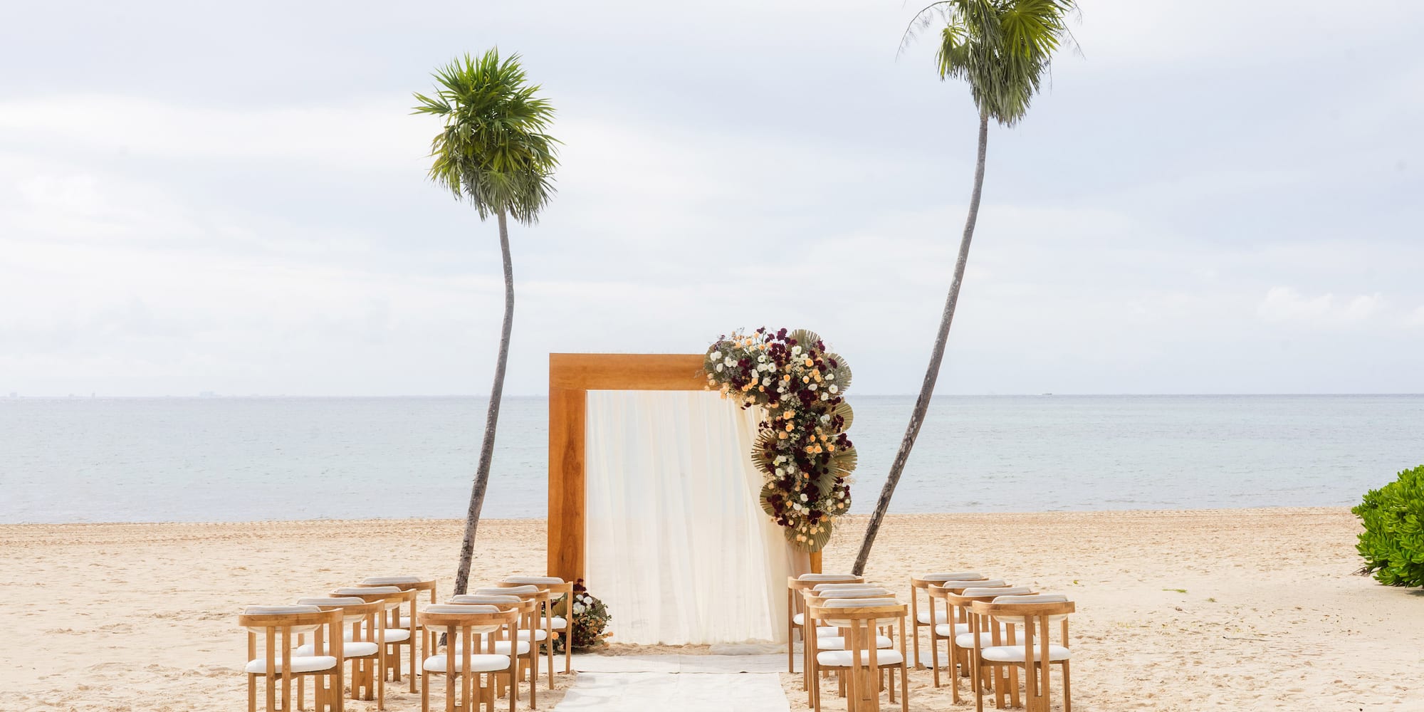 a beach with chairs and a arch
