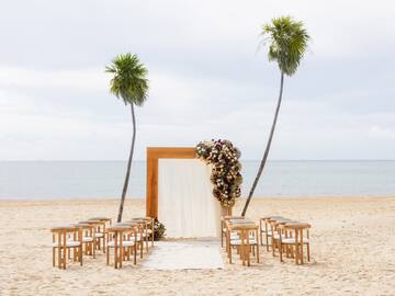 a beach with chairs and a arch