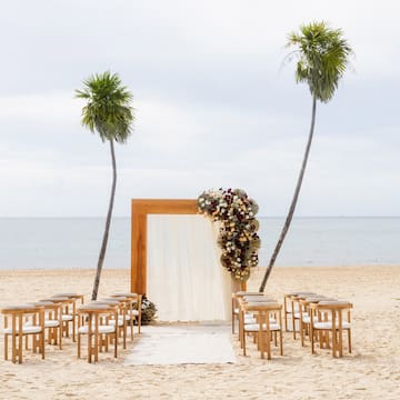 a beach with chairs and a arch