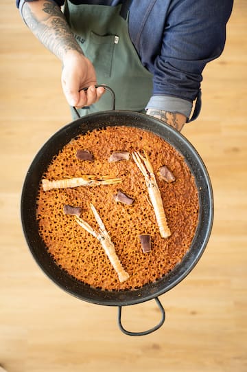 a person holding a pan of food