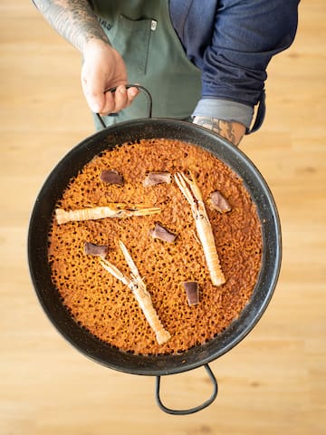a person holding a pan of food