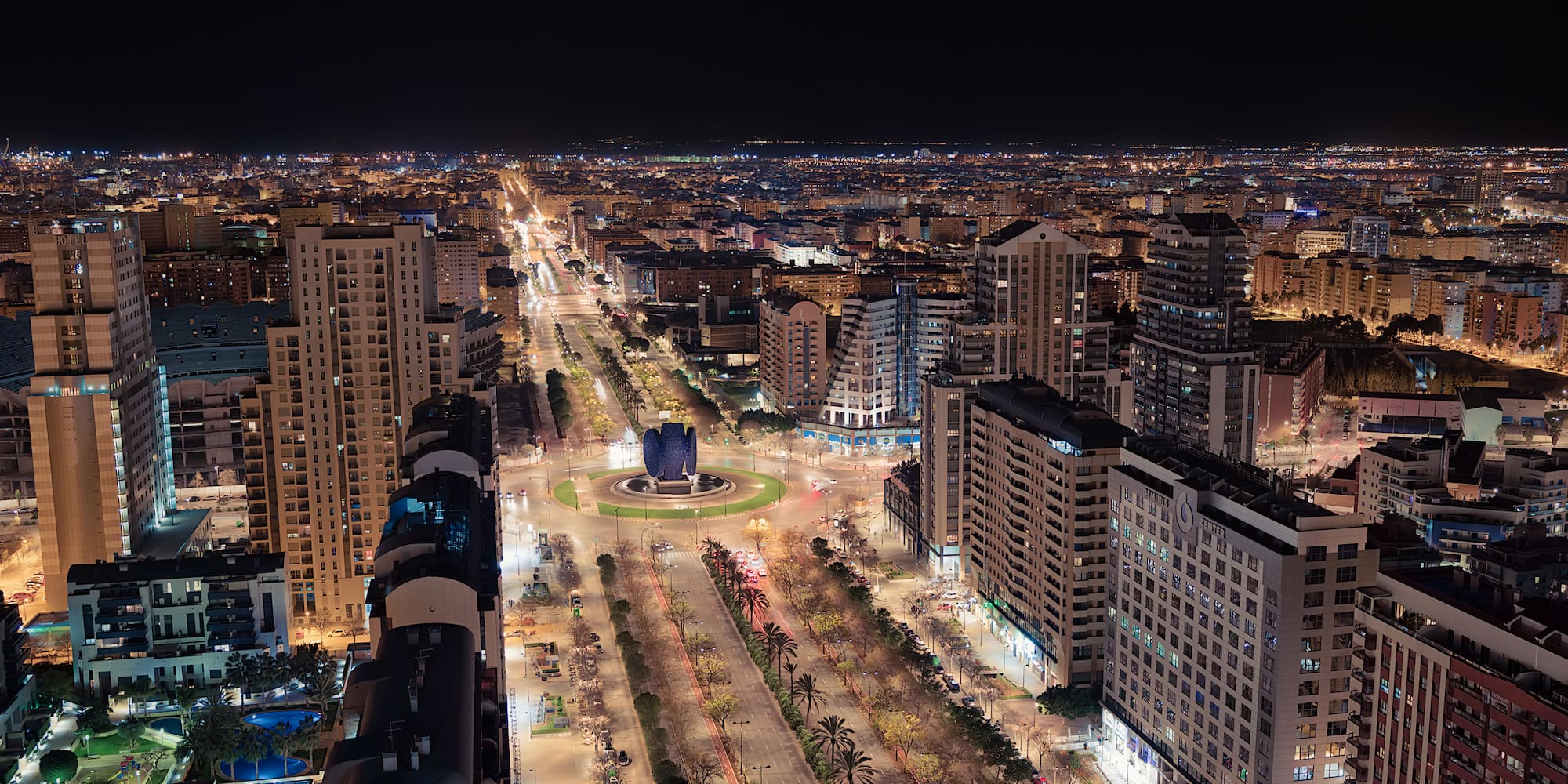 a city at night with many buildings and trees