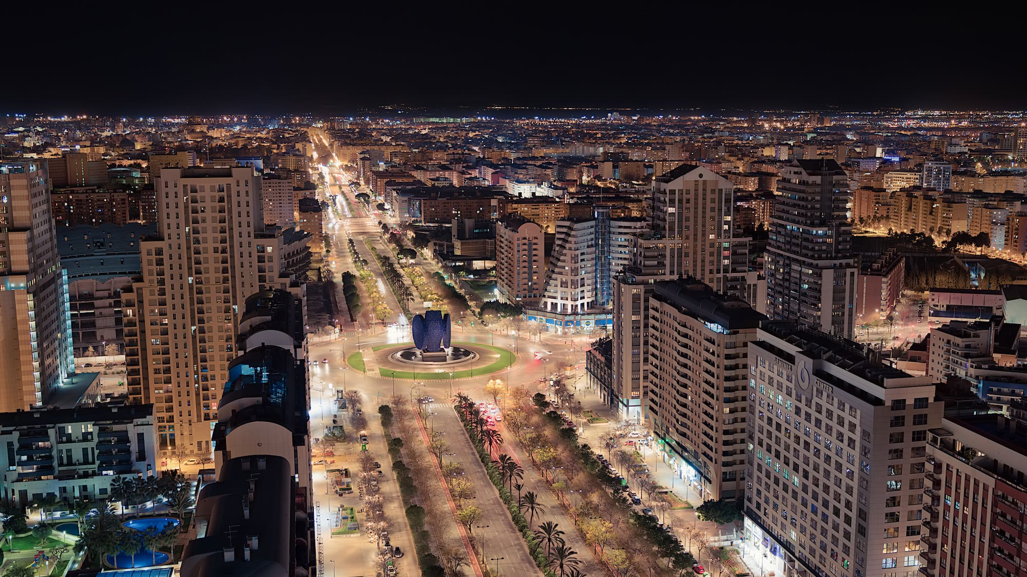 a city at night with many buildings and trees