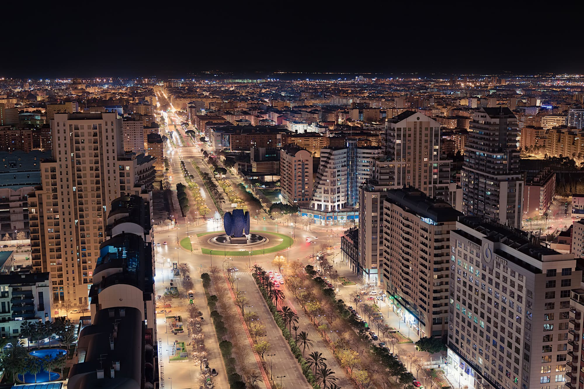 a city at night with many buildings and trees
