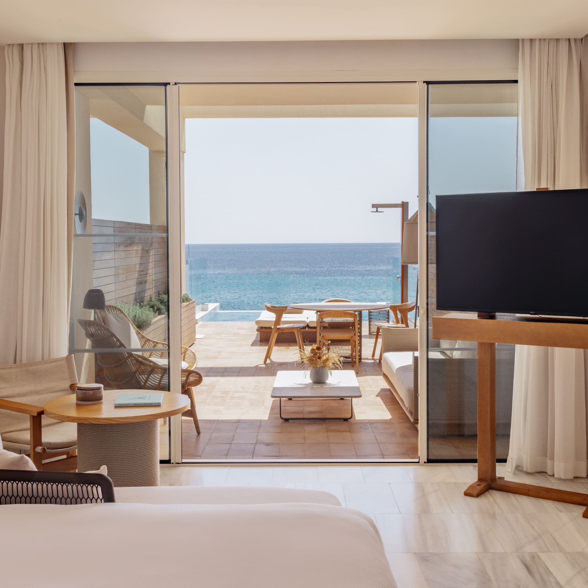 a room with a television and a view of the ocean