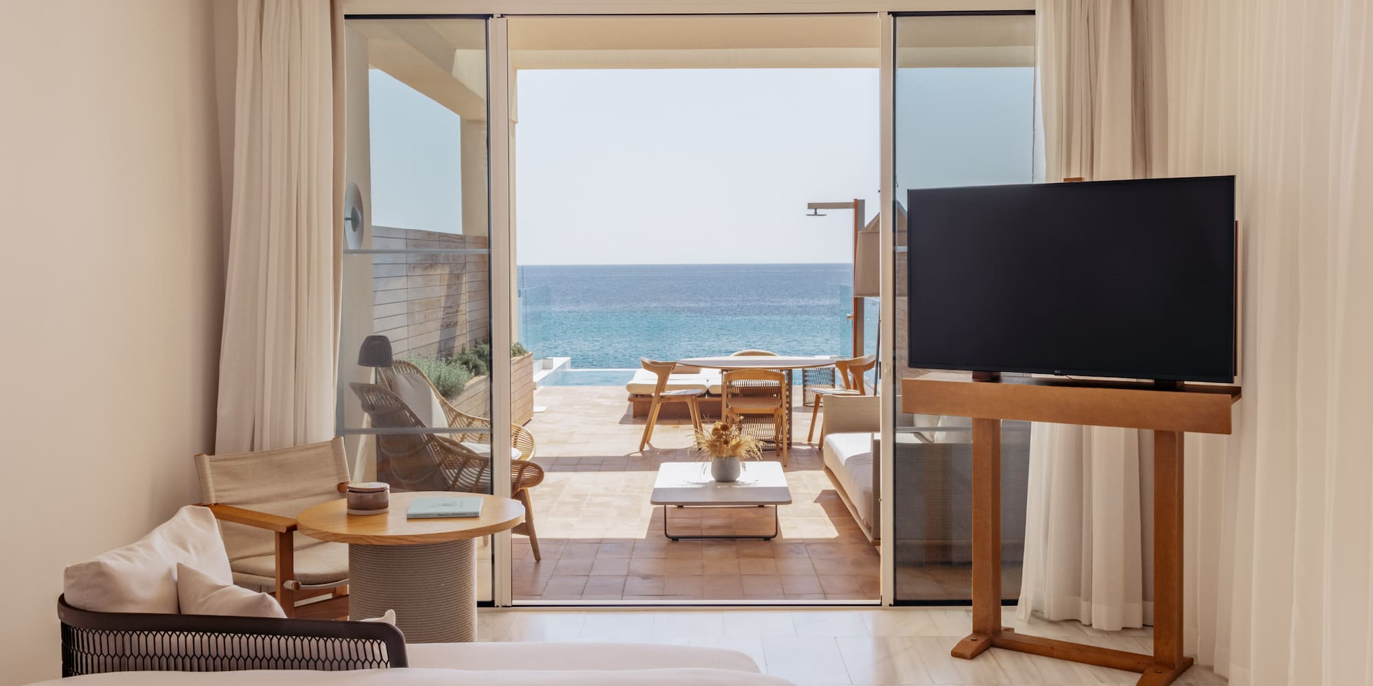 a room with a television and a view of the ocean