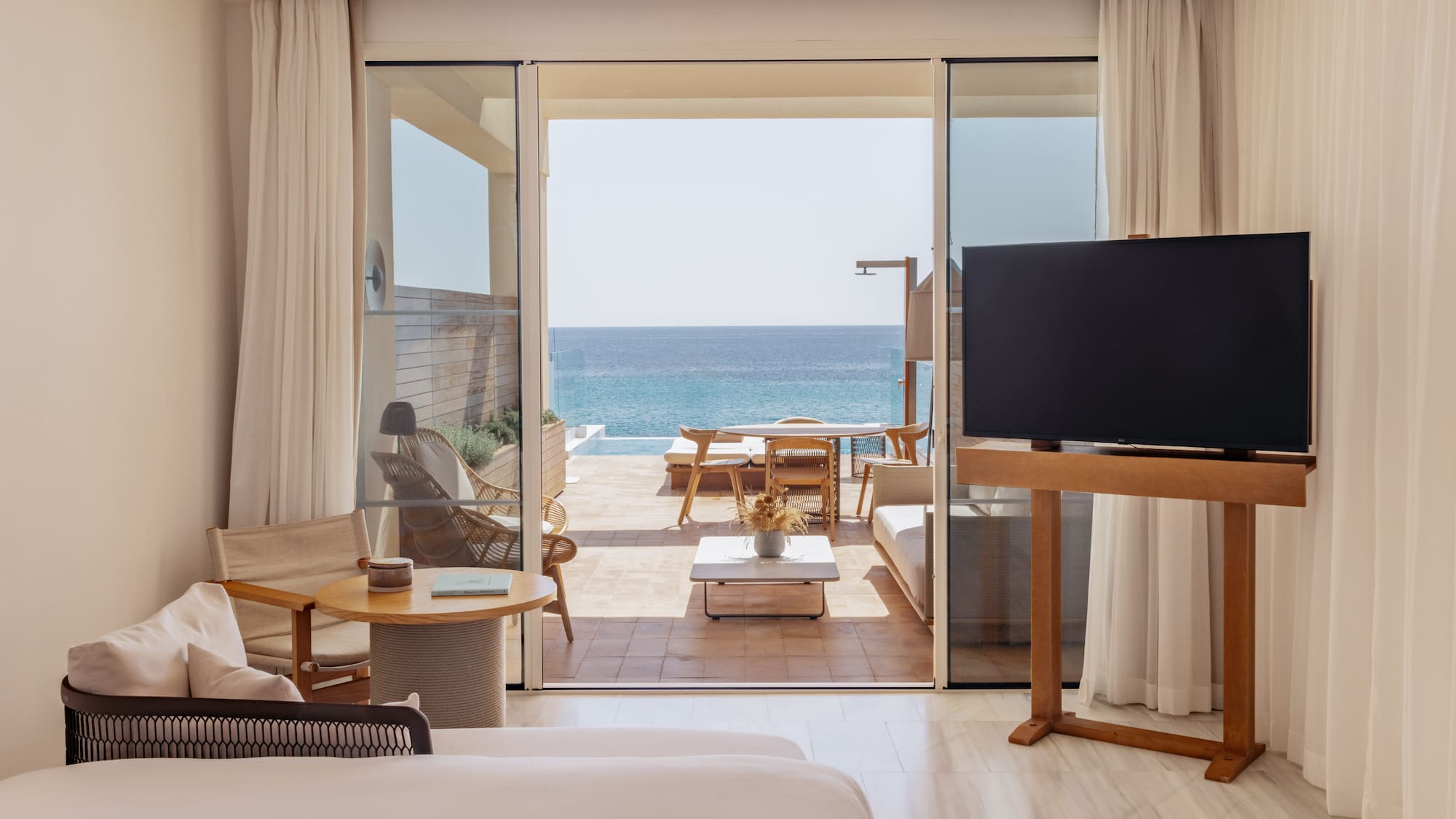 a room with a television and a view of the ocean