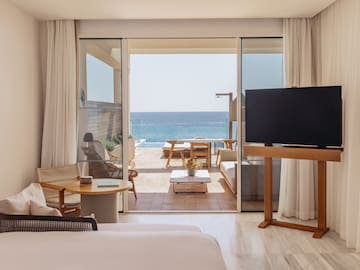 a room with a television and a view of the ocean